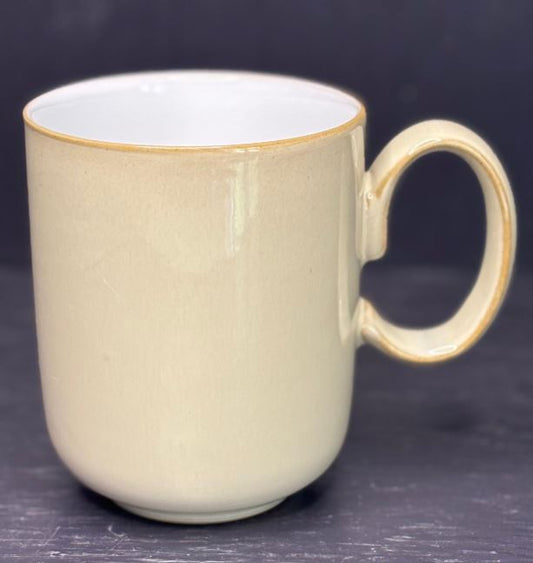 Beige mug with a handle on a dark background