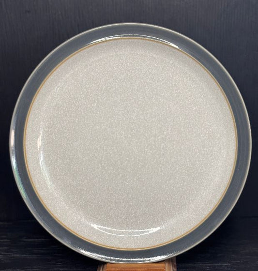 Round ceramic plate with textured surface on a dark background