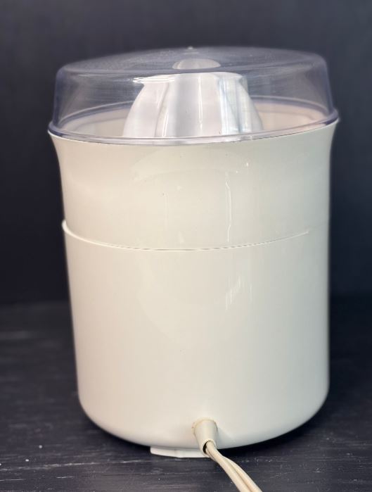 White kitchen appliance with a clear lid on a dark surface