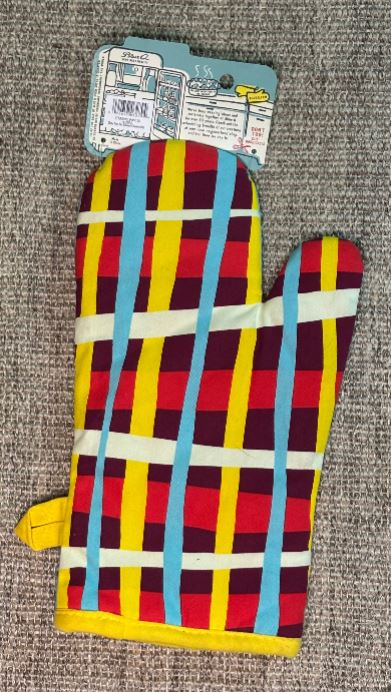 Colorful plaid oven mitt with blue handles on a textured surface