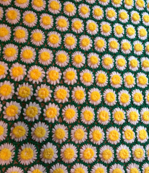 Pattern of small yellow and white flowers on a green background