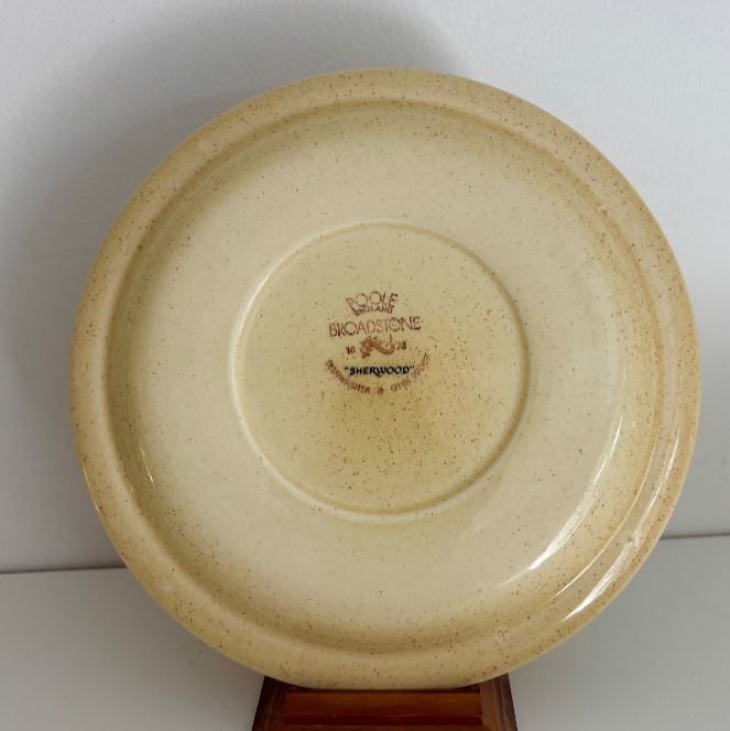 Beige ceramic plate with 'Rolf Bronkhorst' branding on a white background