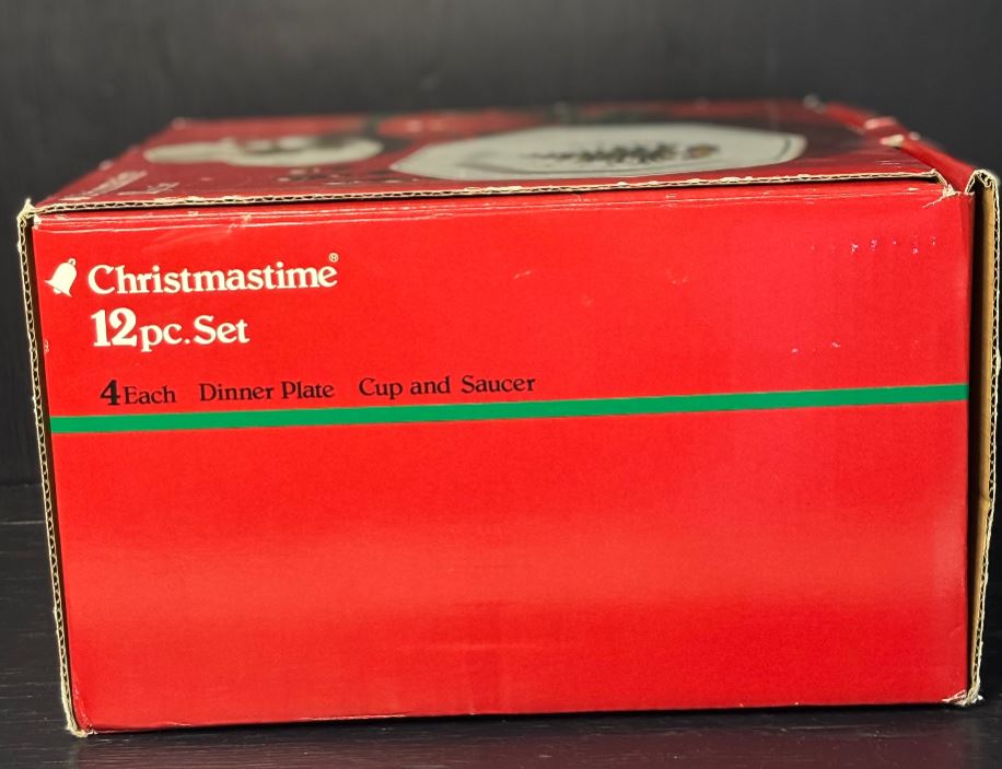 Red cardboard box with Christmas-themed text on a black background