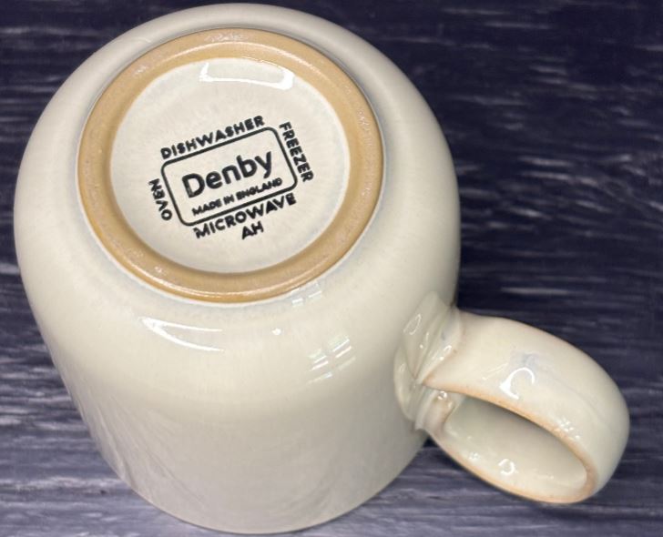 Denby mug with a label on a dark background