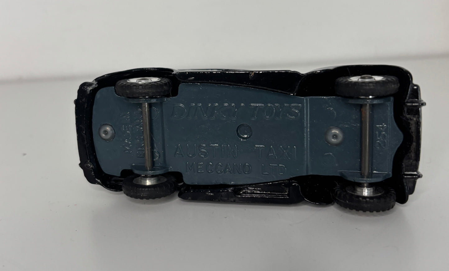 Black toy car chassis with visible branding on a white background