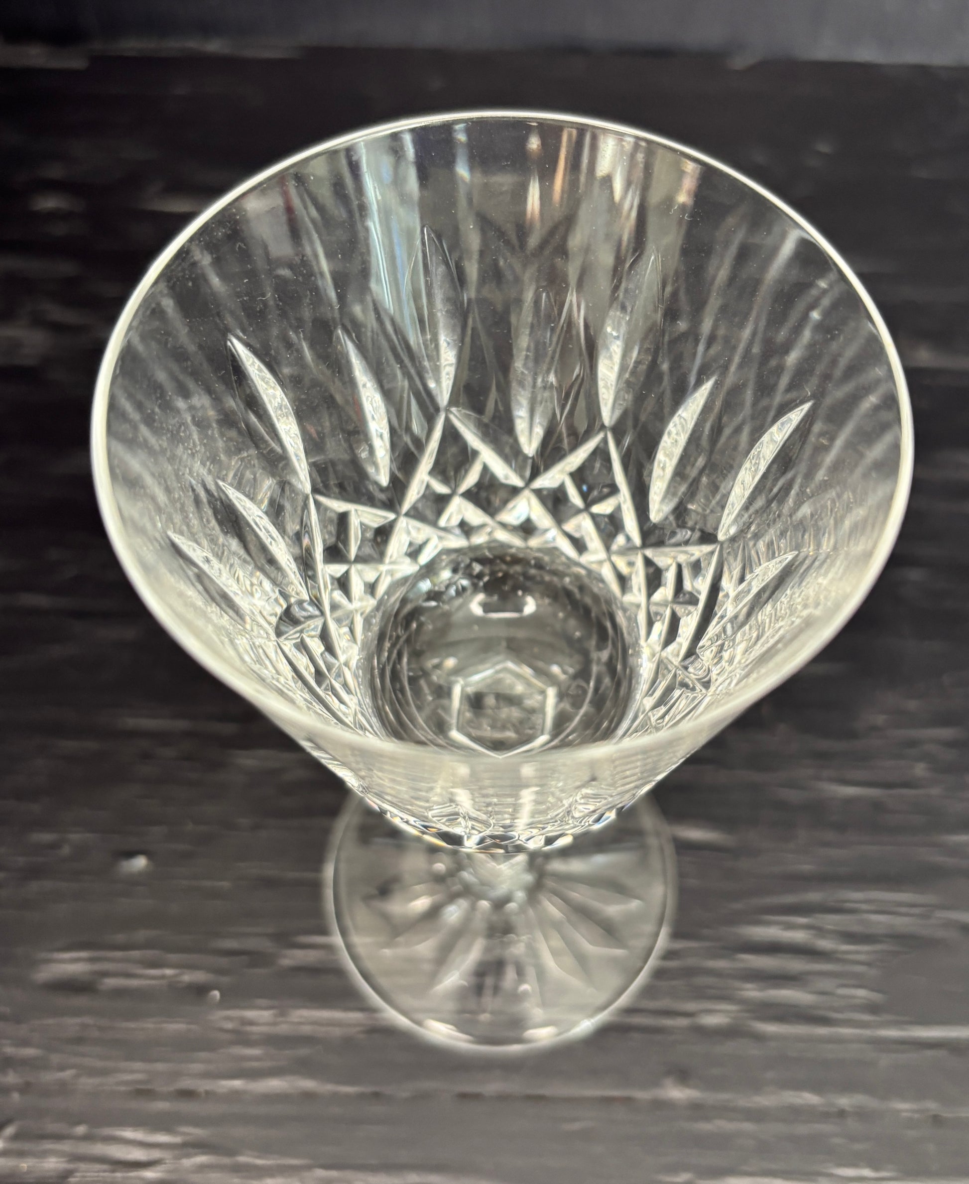 Clear glass with intricate cut patterns on a dark surface