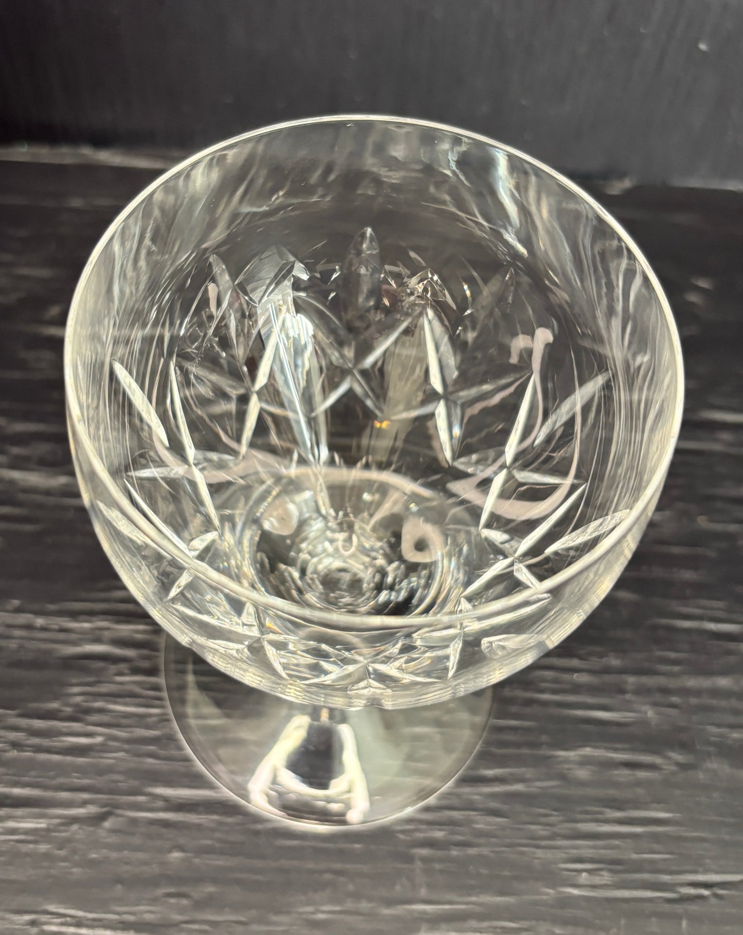 Clear glass with intricate cut design on a dark surface