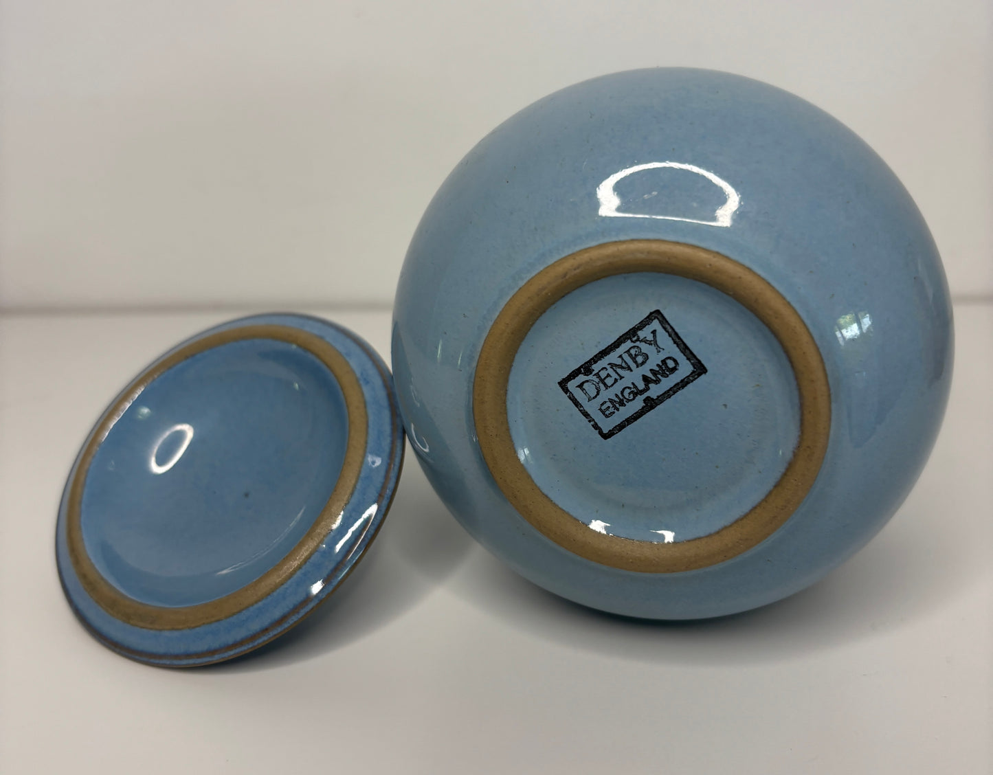 Blue ceramic jar with lid on a white background, featuring Denby England branding.