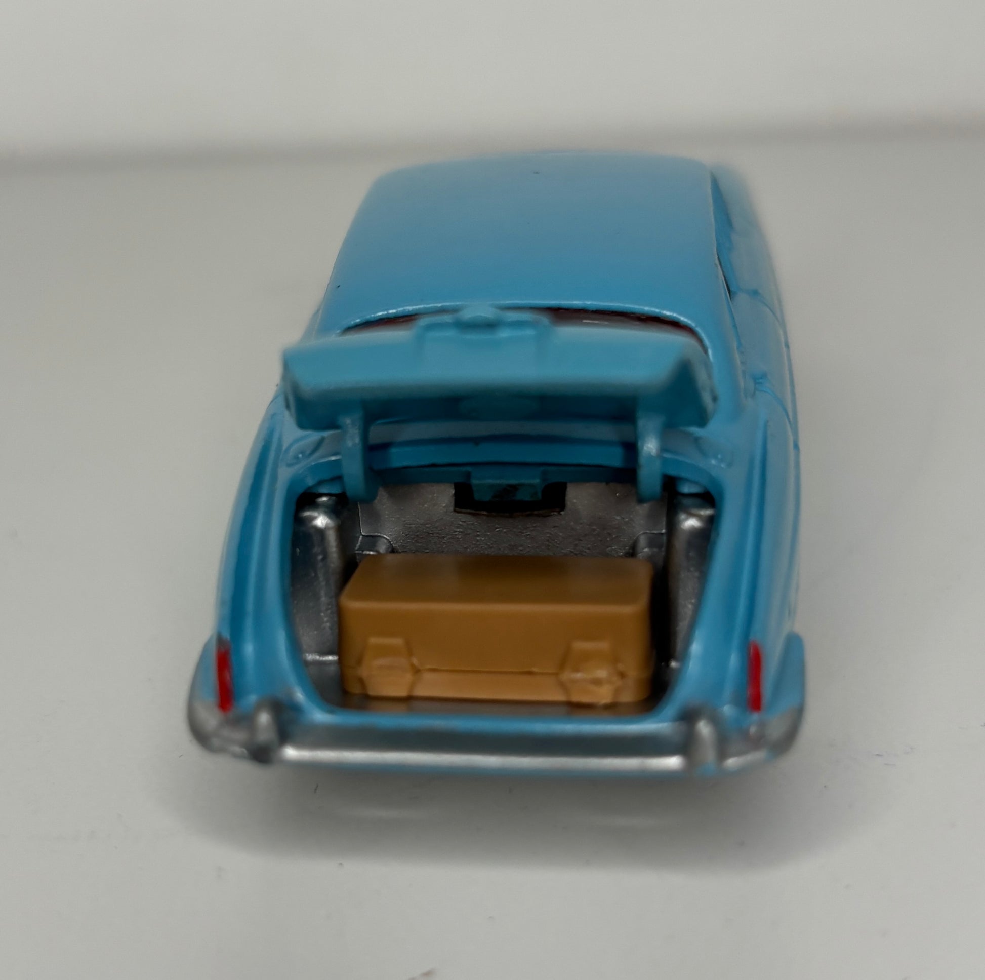 Model car with open trunk and brown box on a white background