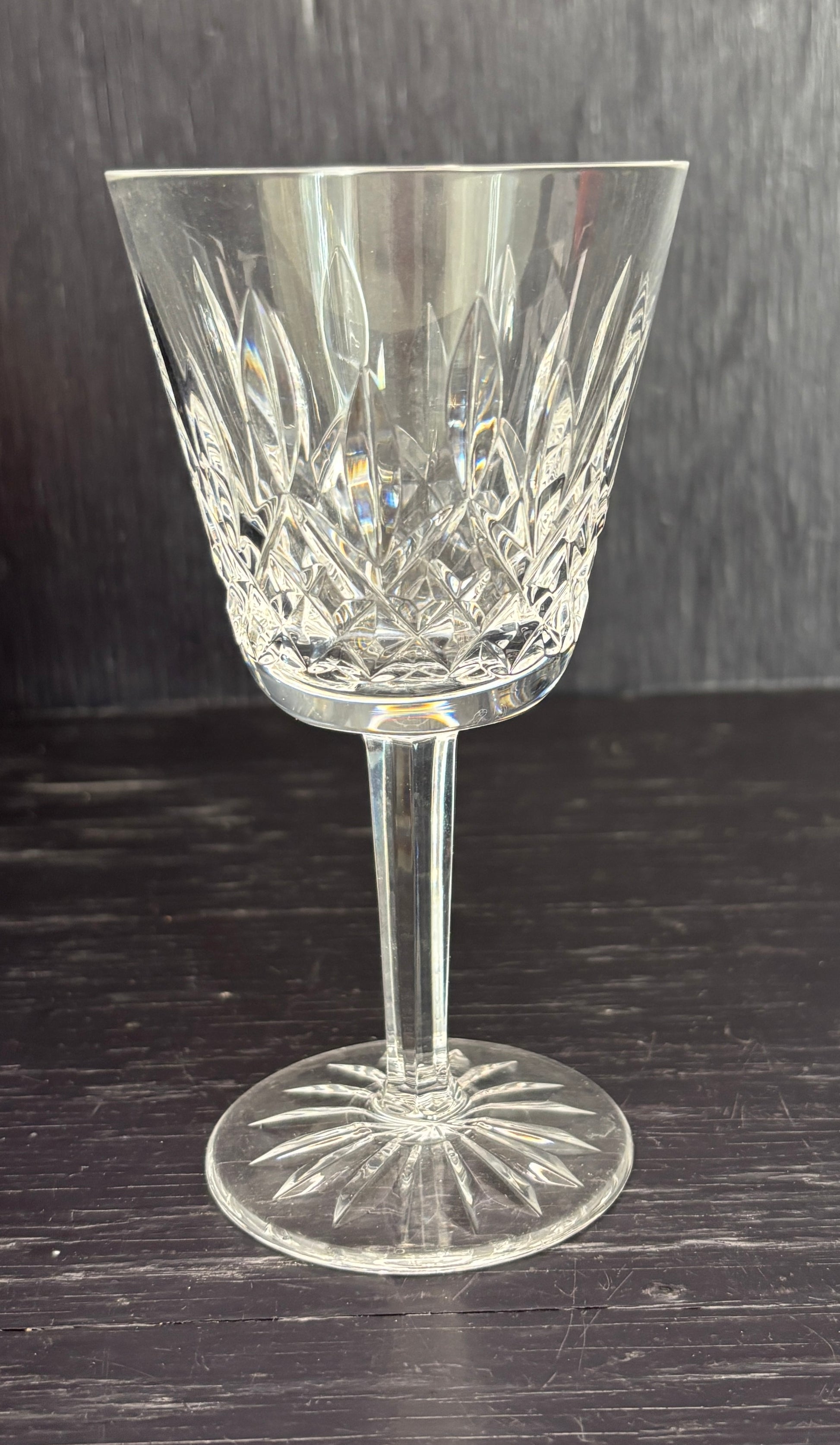 Crystal wine glass on a dark wooden surface