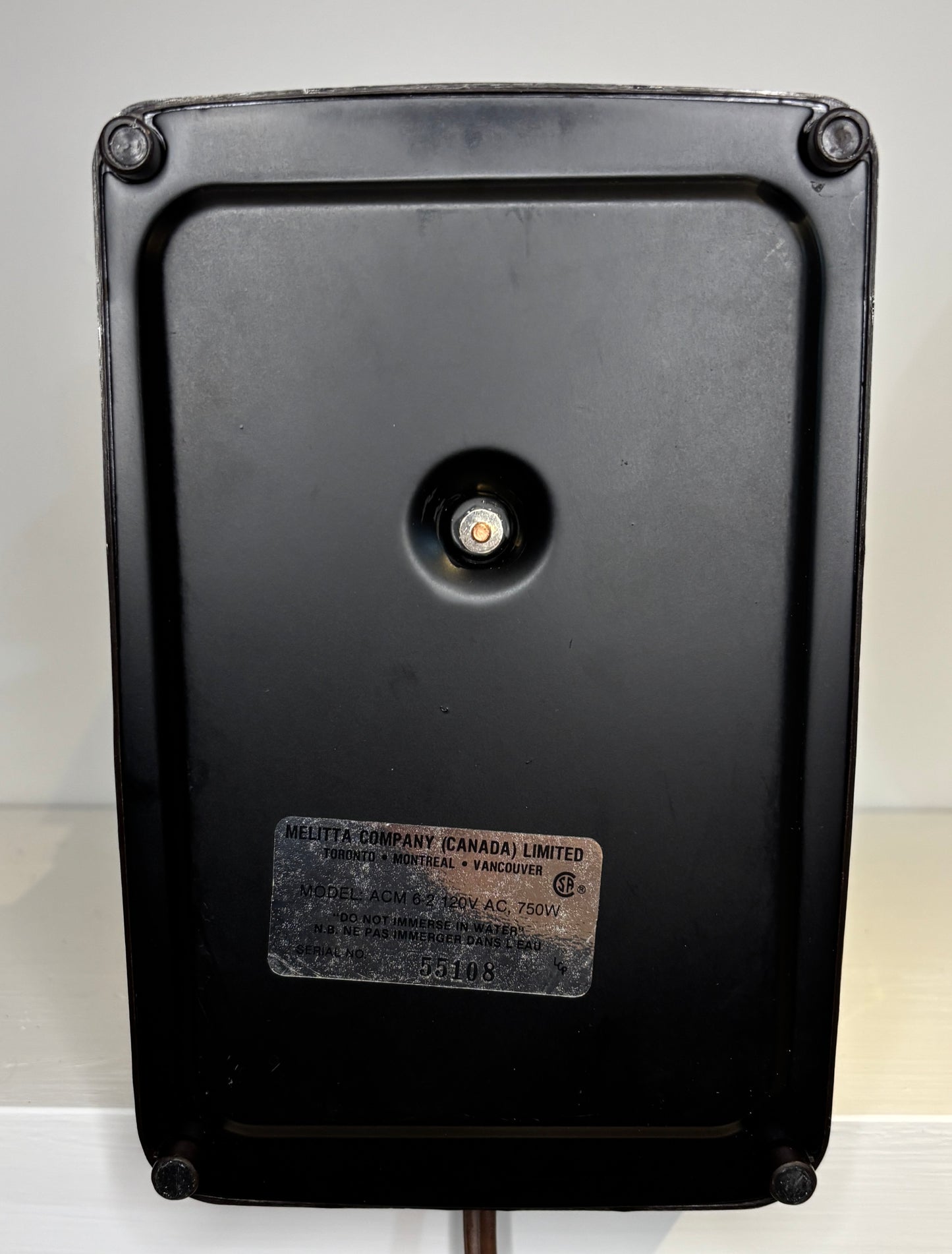 Black metal box with a label on a white background