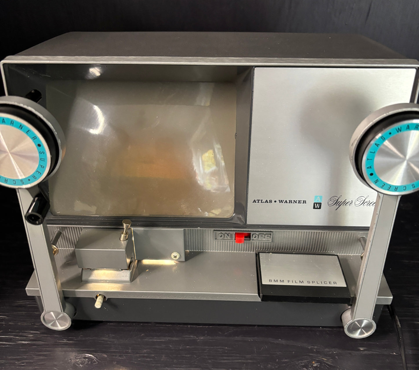 Vintage film processor with 'Atlas & Warner' branding on a dark background