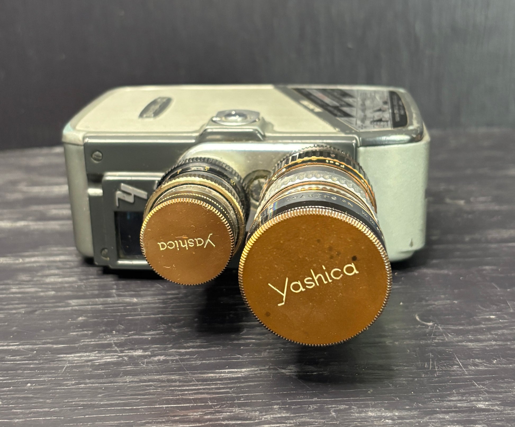 Close-up of a Yashica camera with two lenses on a dark surface