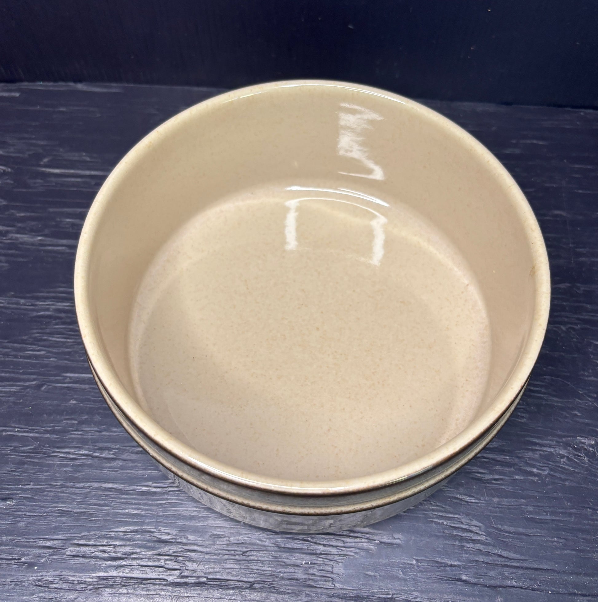 Beige ceramic bowl on a dark blue surface