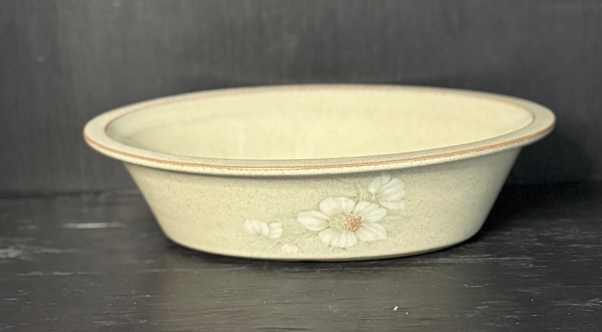 Decorative ceramic bowl with floral patterns on a dark surface