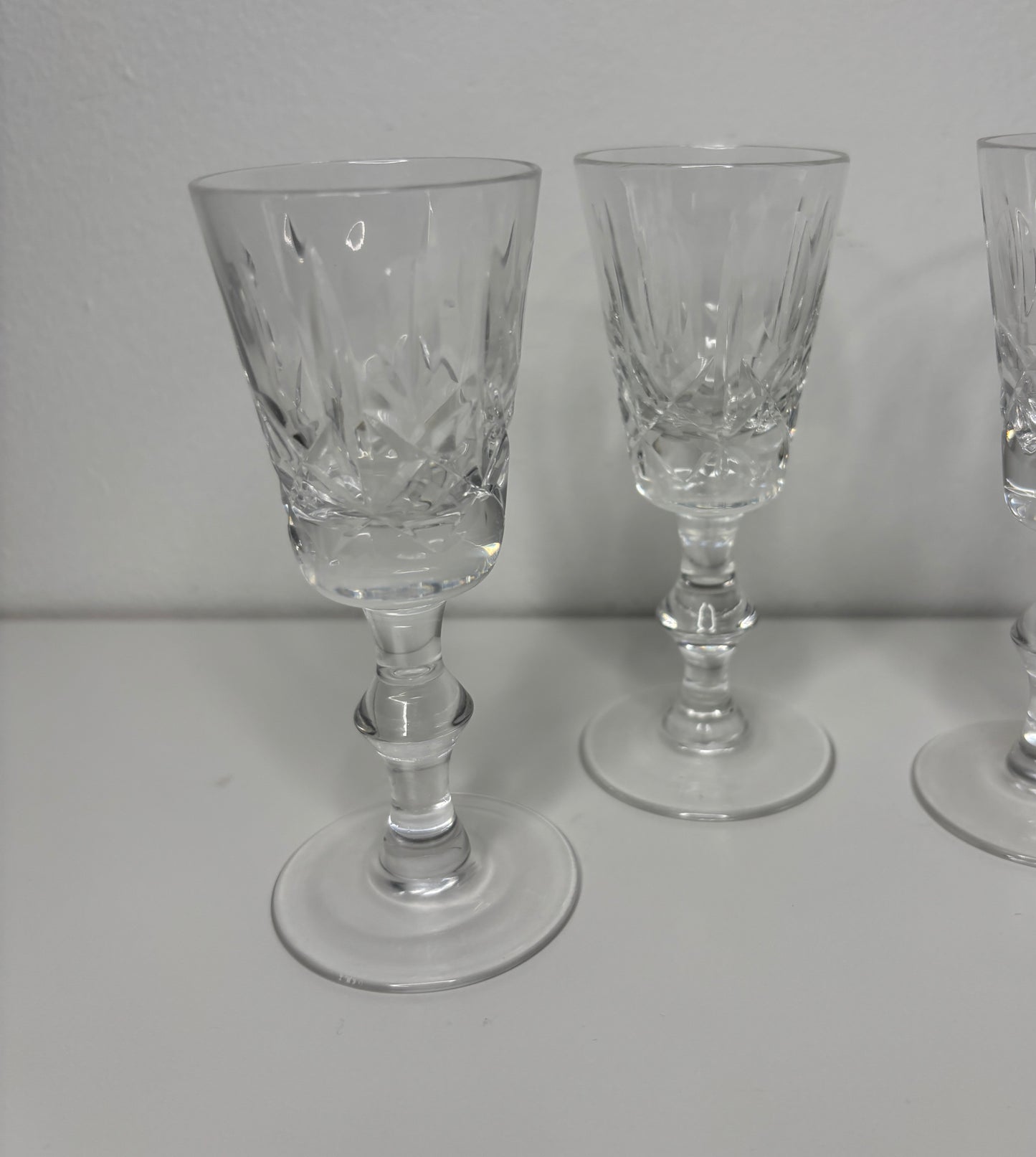 Set of three clear glass goblets on a white surface with a plain background