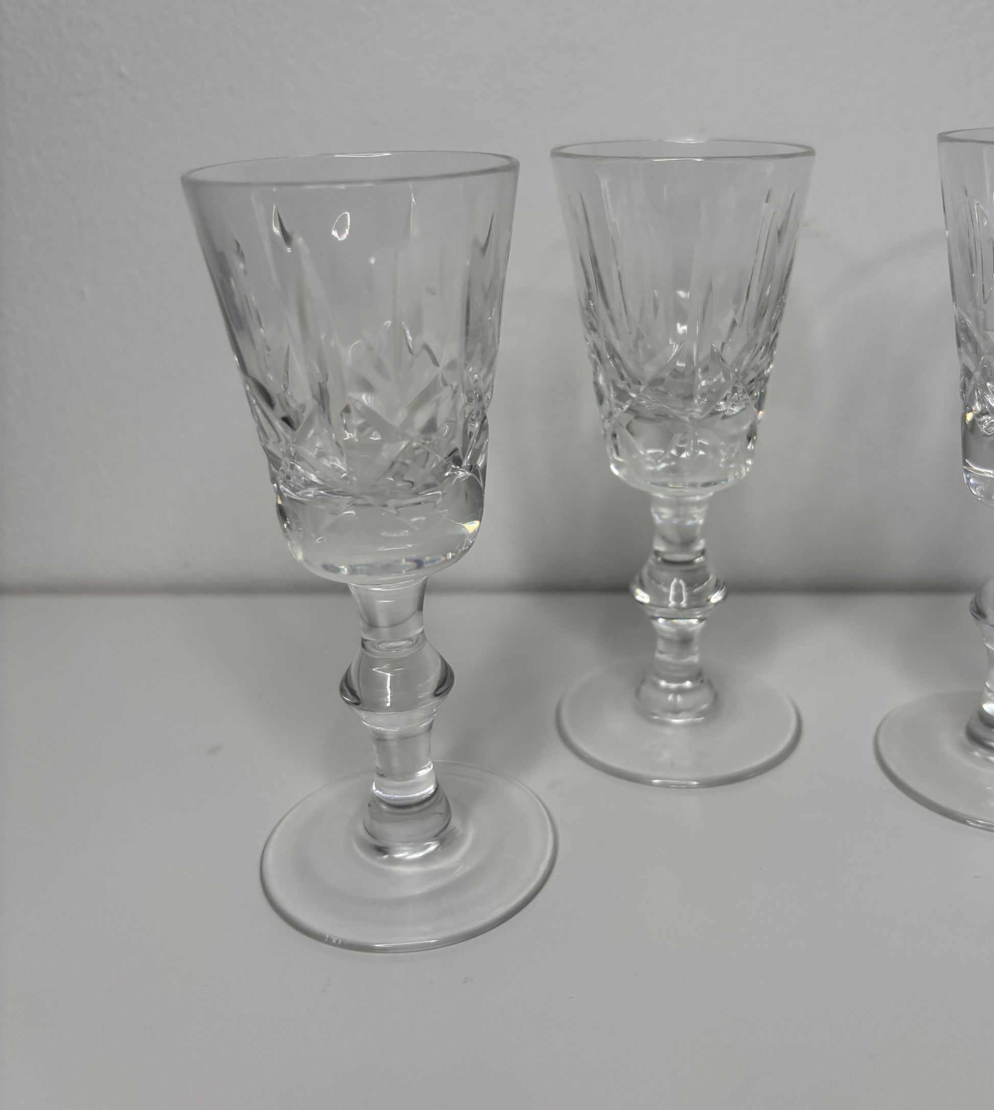 Set of three clear glass goblets on a white surface with a plain background