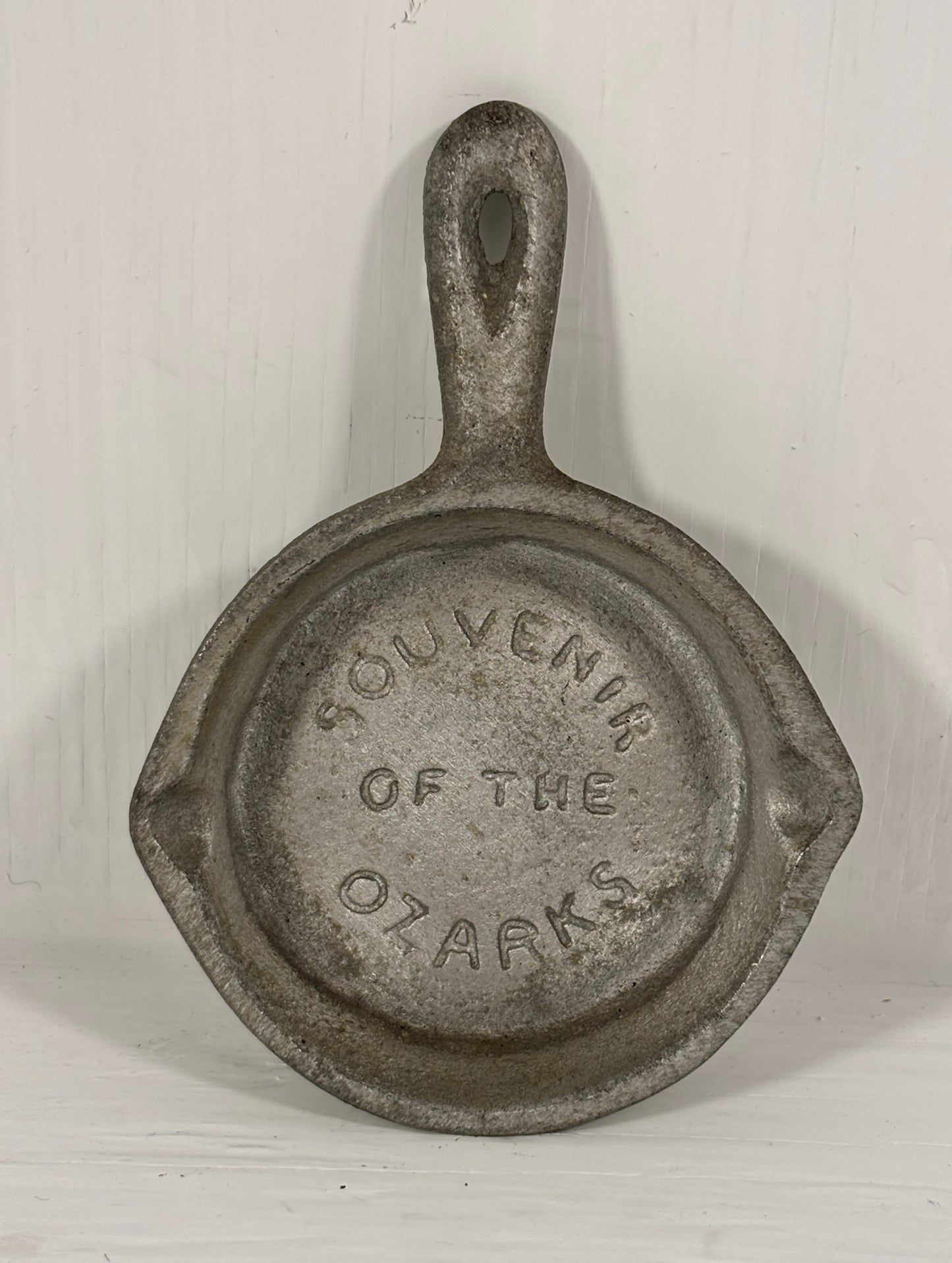 Small cast iron skillet with 'Souvenir of the Ozarks' text on a white background