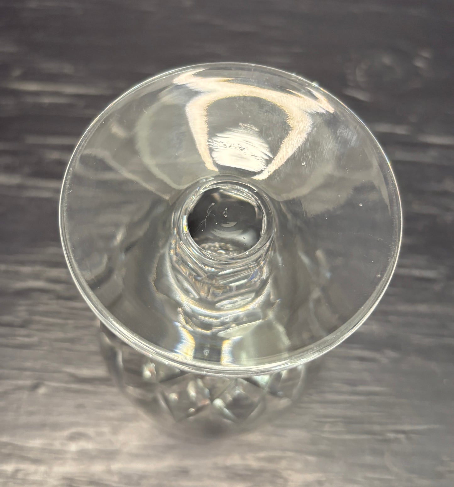 Clear glass candle holder on a dark textured surface