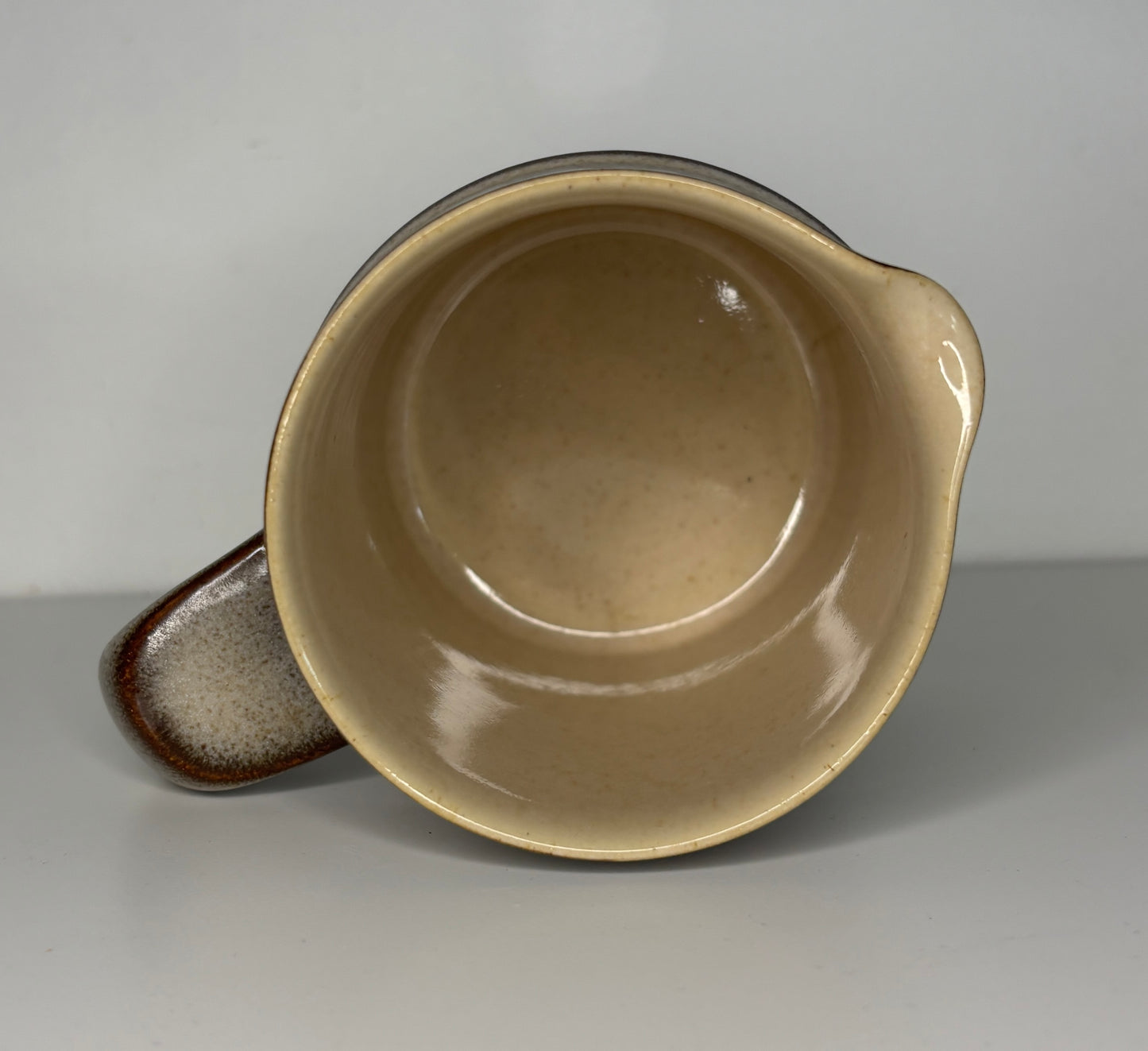 Ceramic bowl with brown interior and exterior on a gray background
