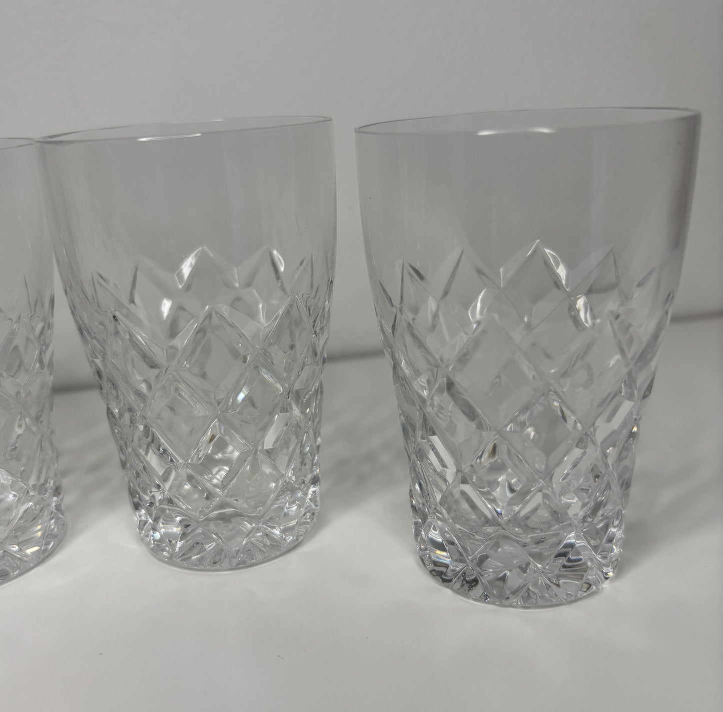 Set of three crystal glasses with diamond pattern on a white background