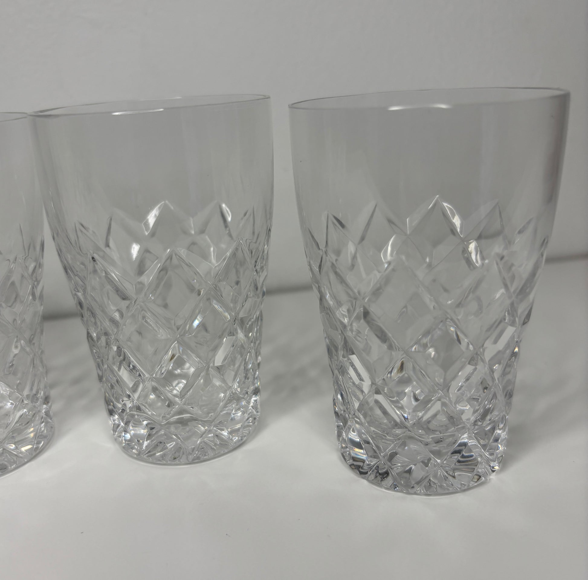 Set of three crystal glasses with diamond pattern on a white background