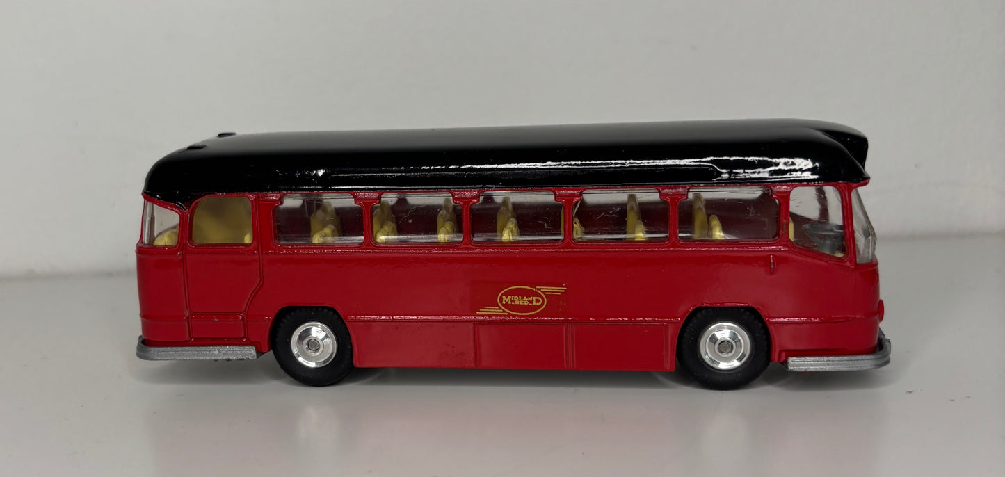 Model bus with a black top and red body on a gray background
