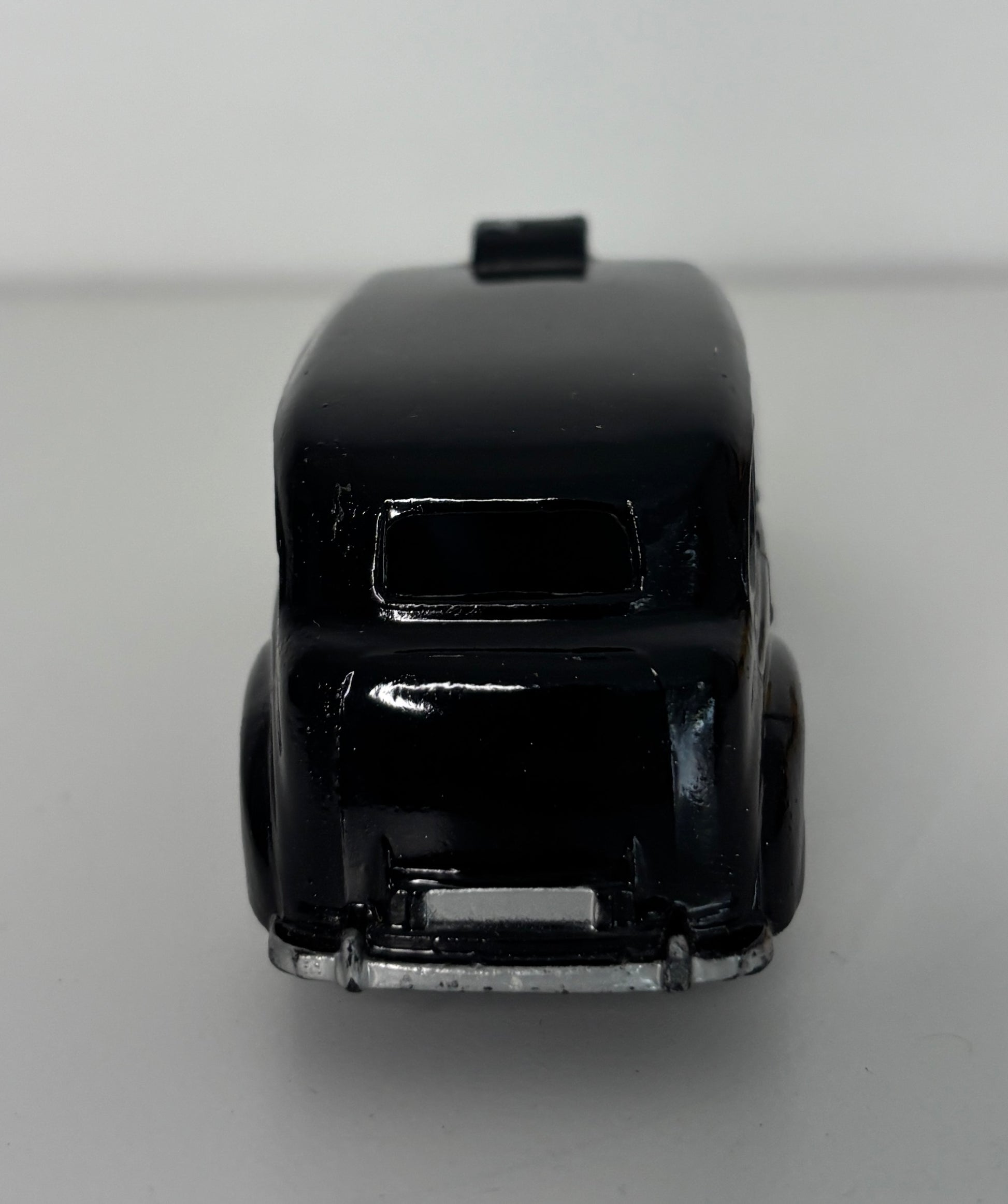 Black toy car on a gray background