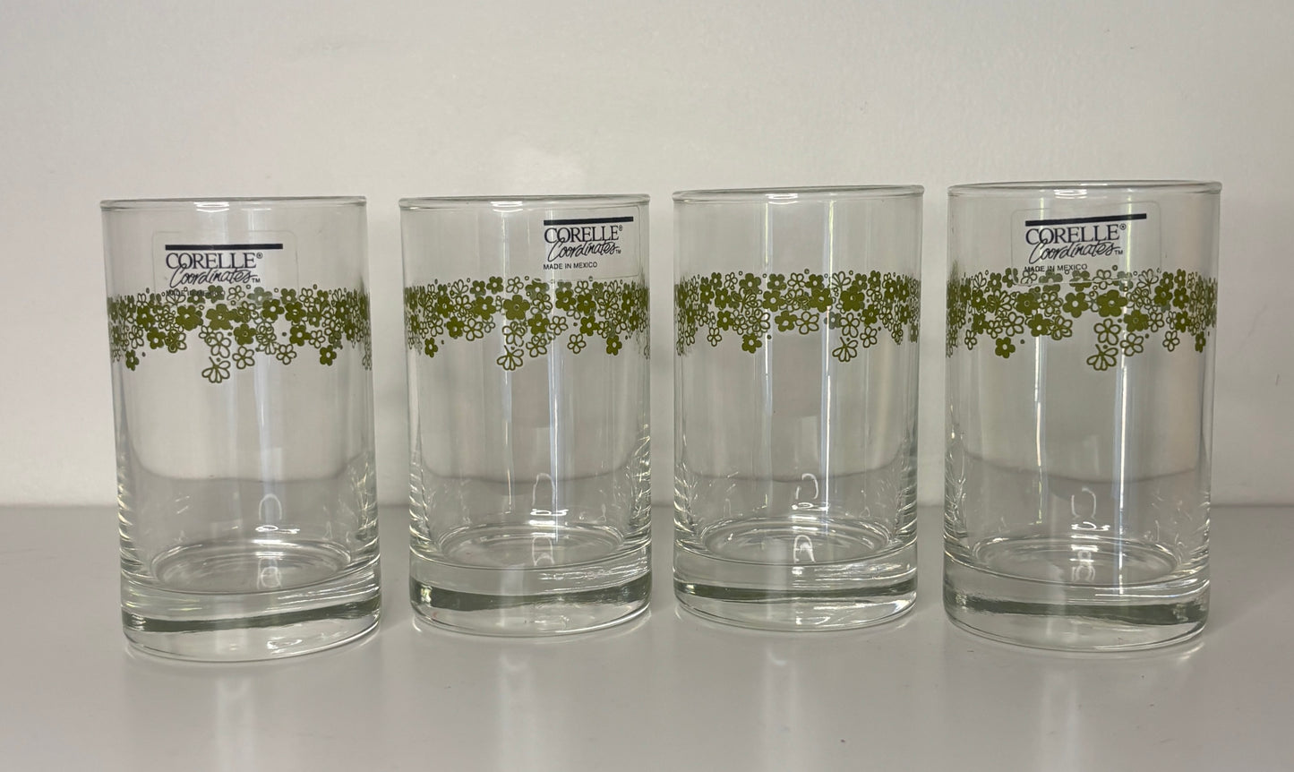 Four Corolle tumblers with green floral design on a white background