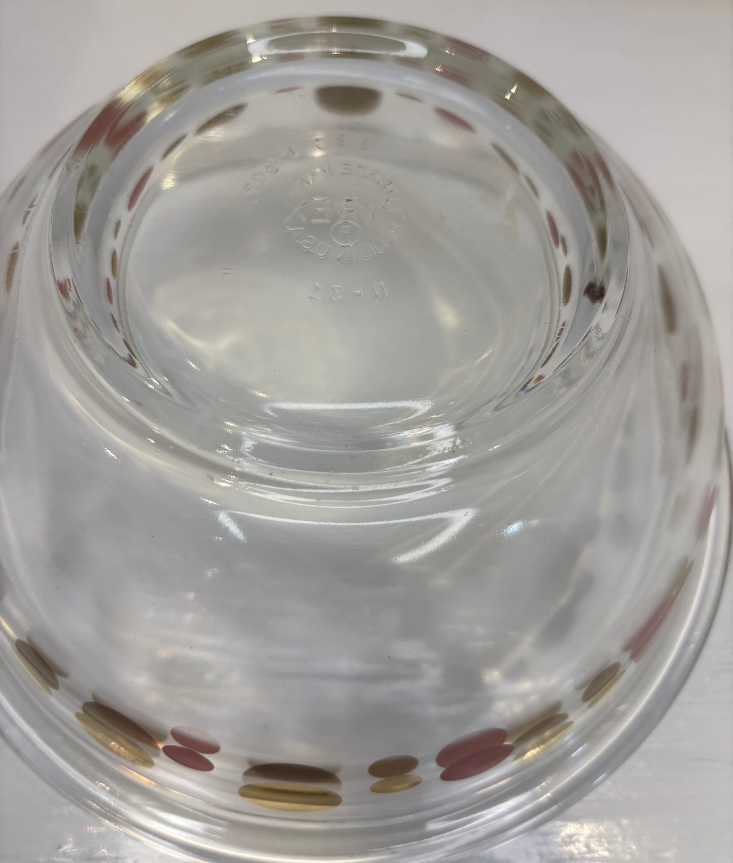 Clear glass bowl with decorative polka dot rim on a white background