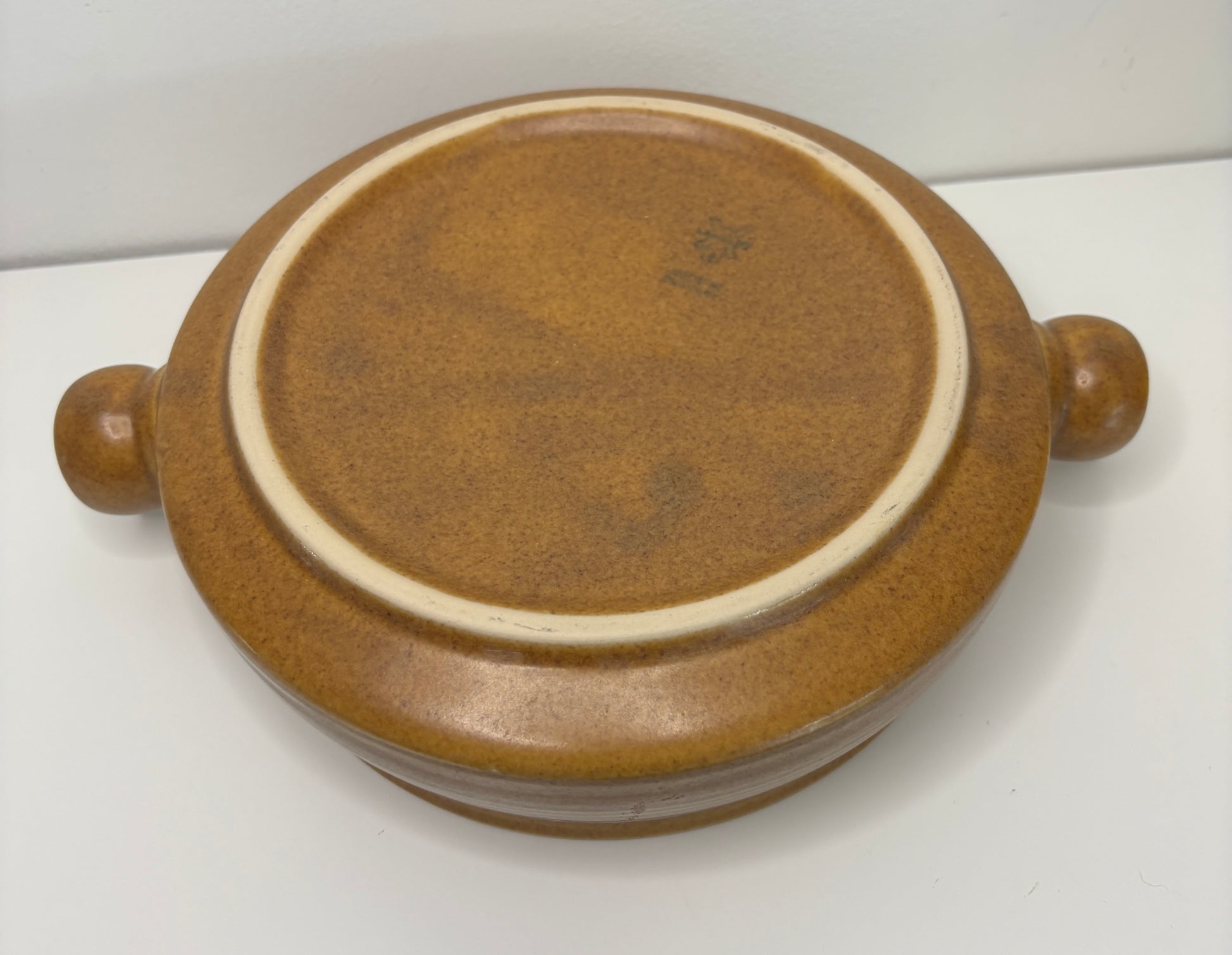 Brown ceramic dish with two handles on a white background
