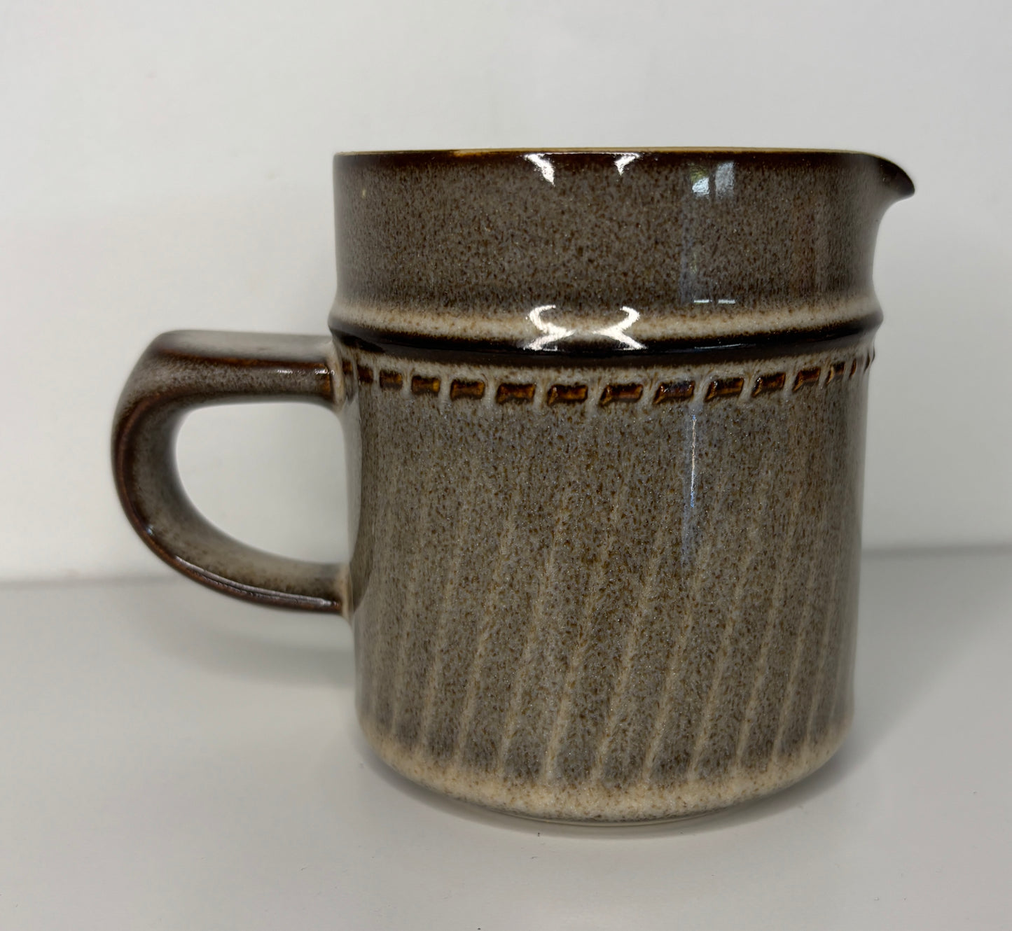 Brown ceramic pitcher on a white background