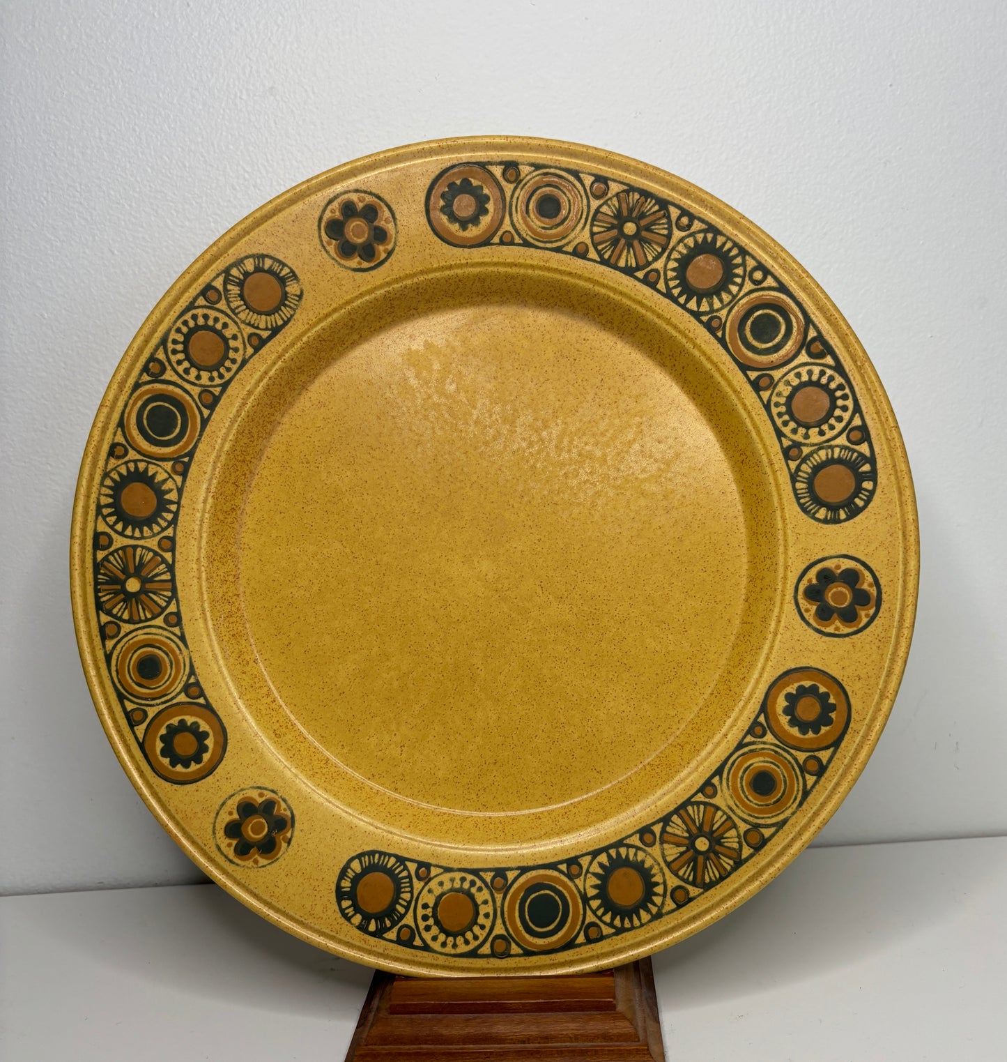 Decorative ceramic plate with brown and black patterns on a white background