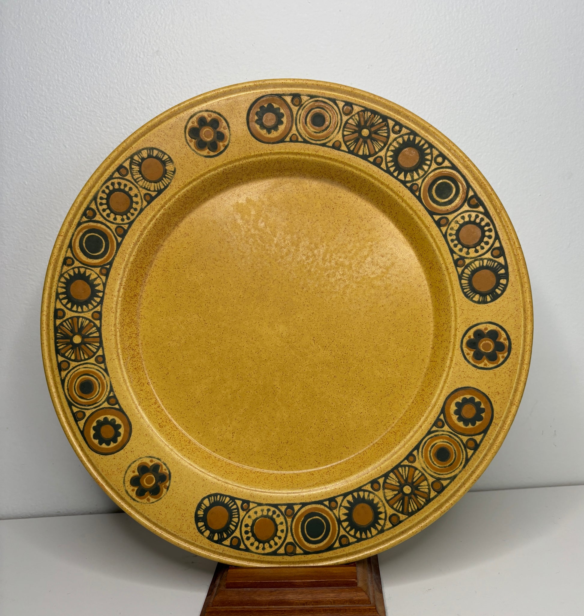 Decorative ceramic plate with brown and black patterns on a white background