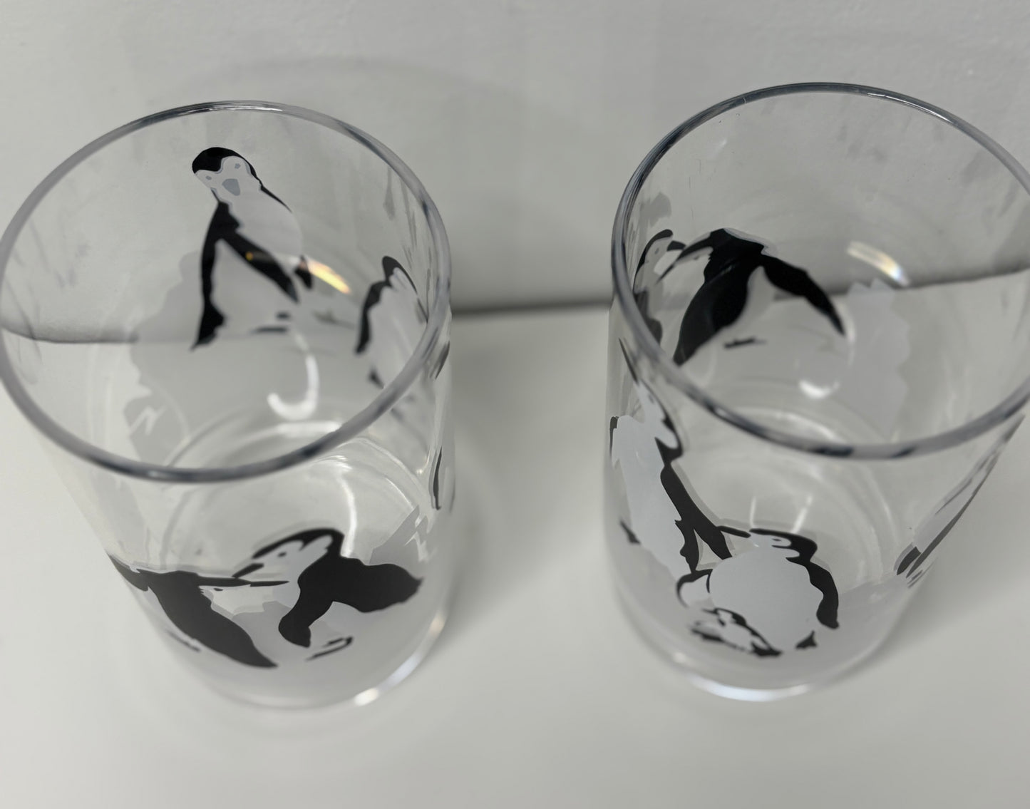 Two glass tumblers with black and white illustrations on a white background