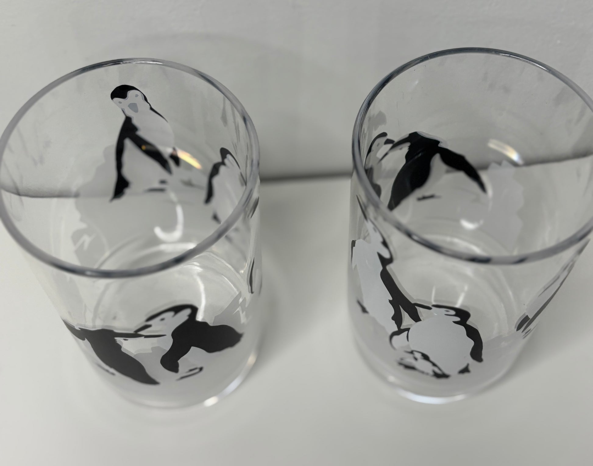 Two glass tumblers with black and white illustrations on a white background
