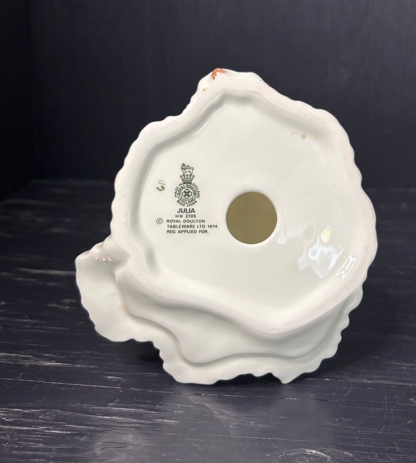 White ceramic product with branding on a dark surface