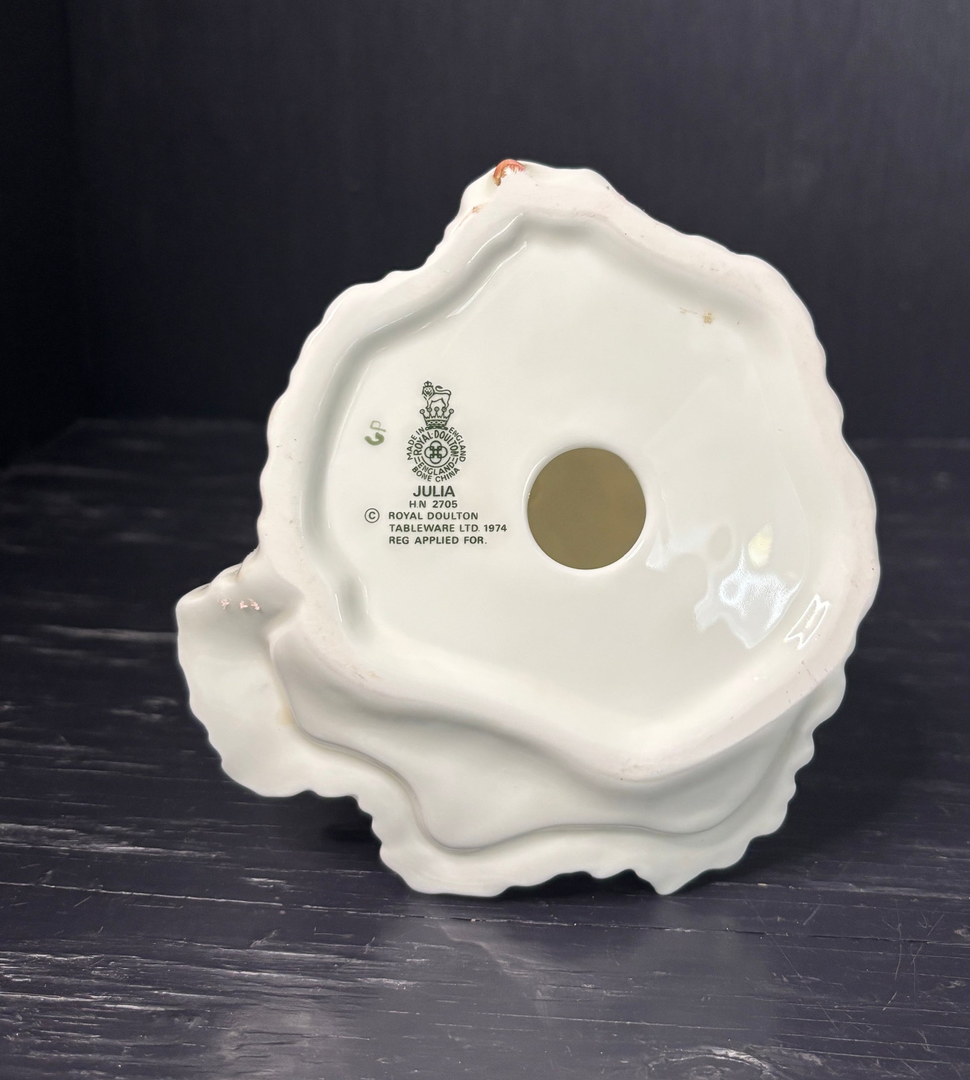 White ceramic product with branding on a dark surface