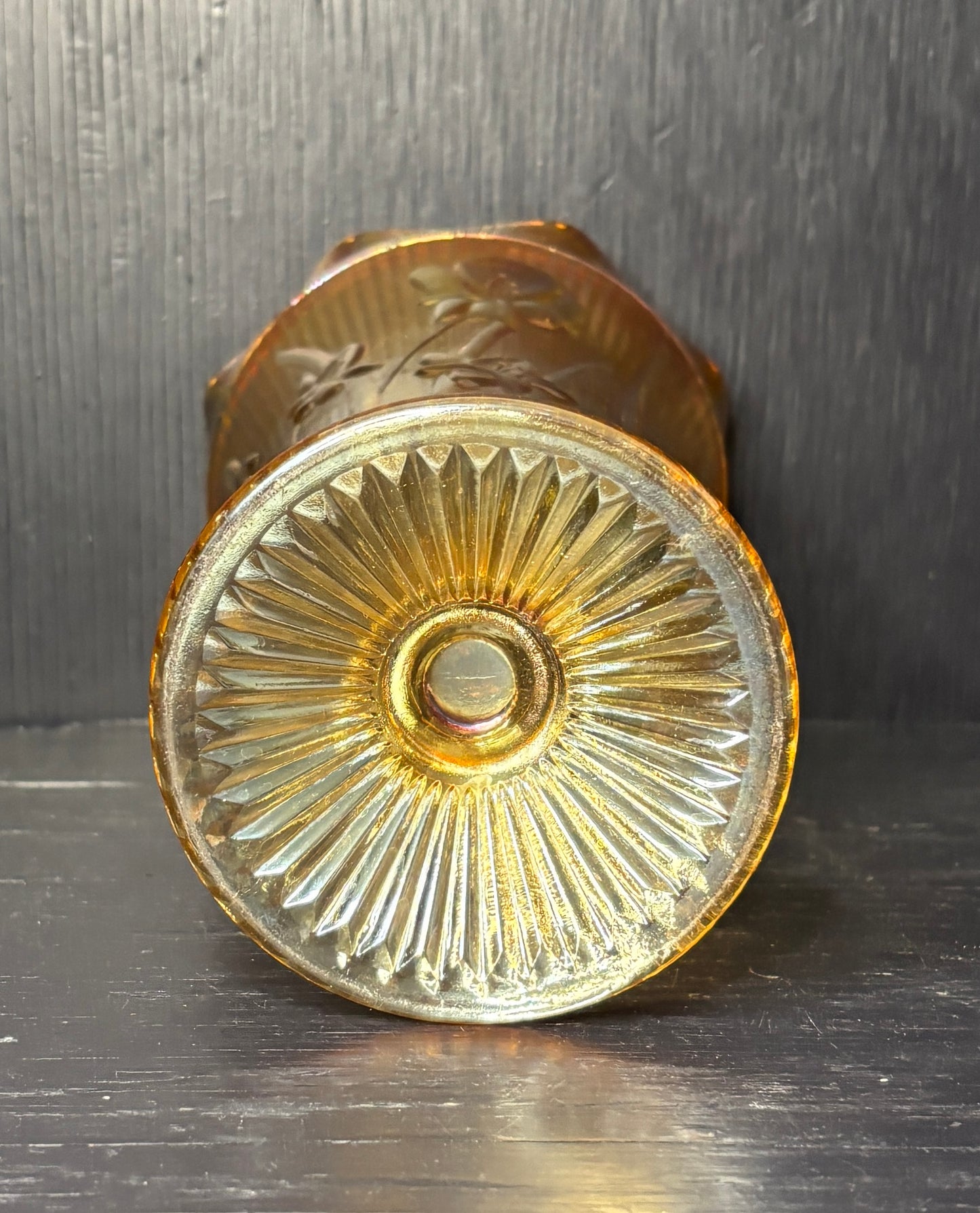 Decorative brass doorknob with intricate design on a dark background