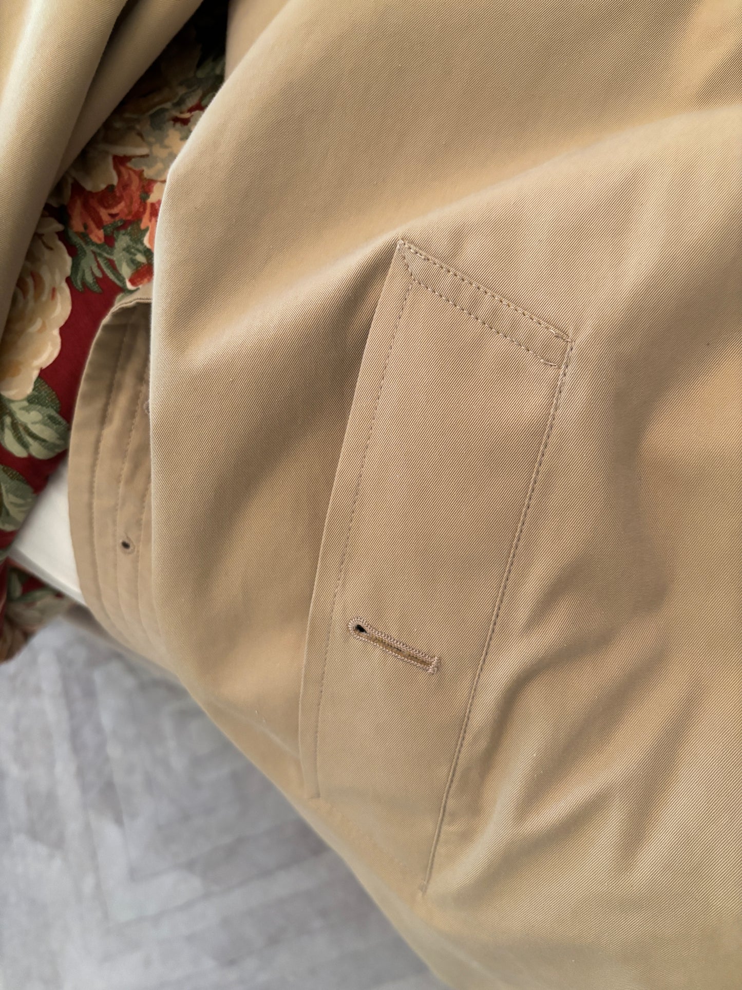 Close-up of beige pants with a pocket detail, blurred background