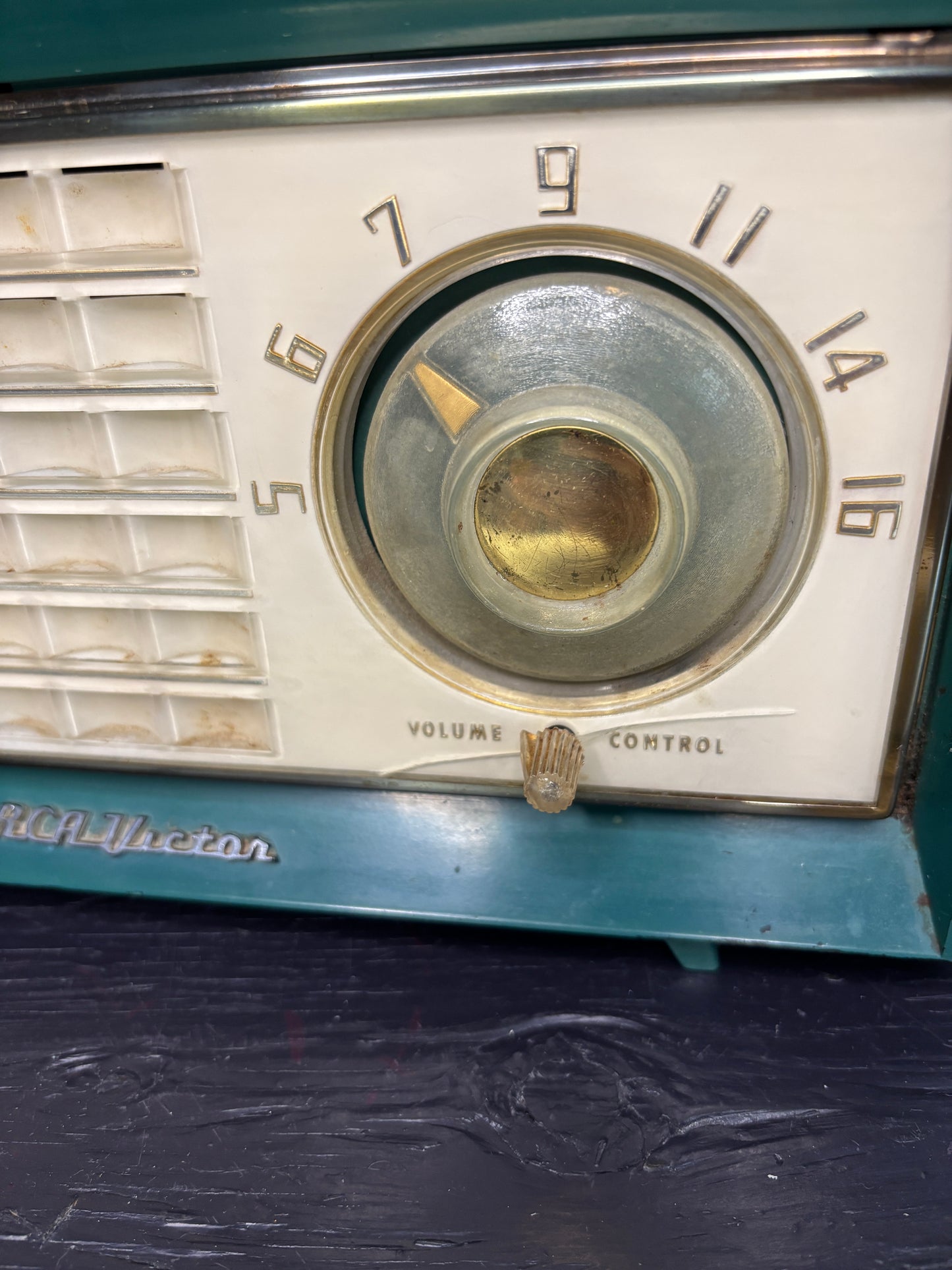 Vintage radio dial with numbers and a brand name on a dark background