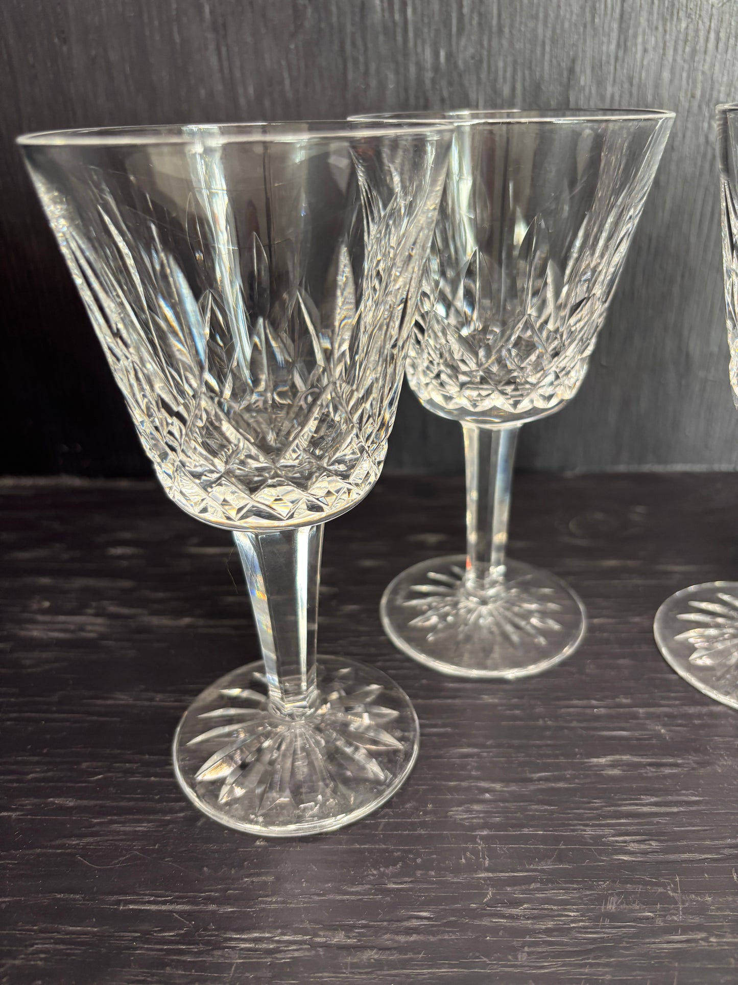 Set of crystal wine glasses on a dark wooden surface