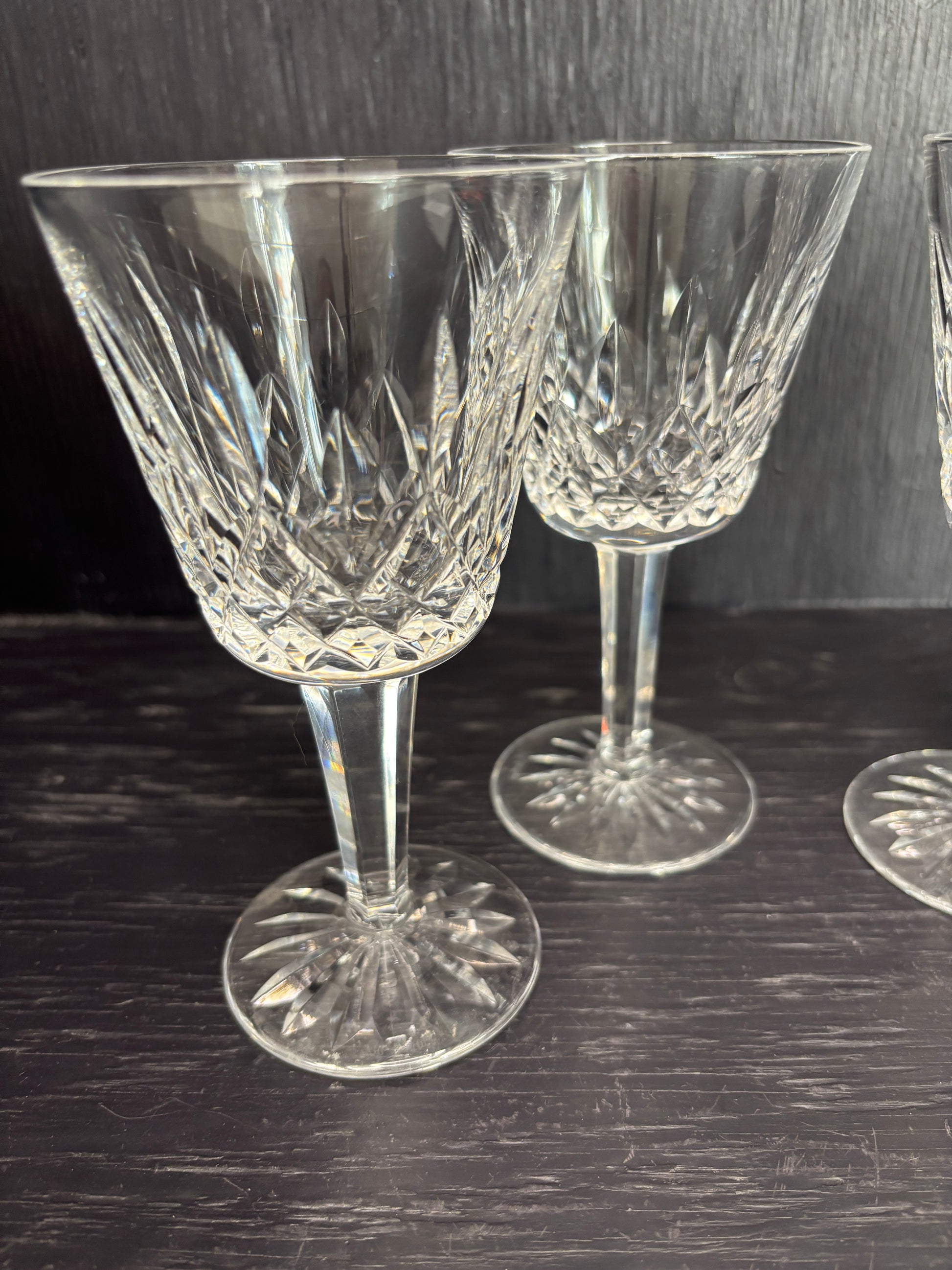 Set of crystal wine glasses on a dark wooden surface