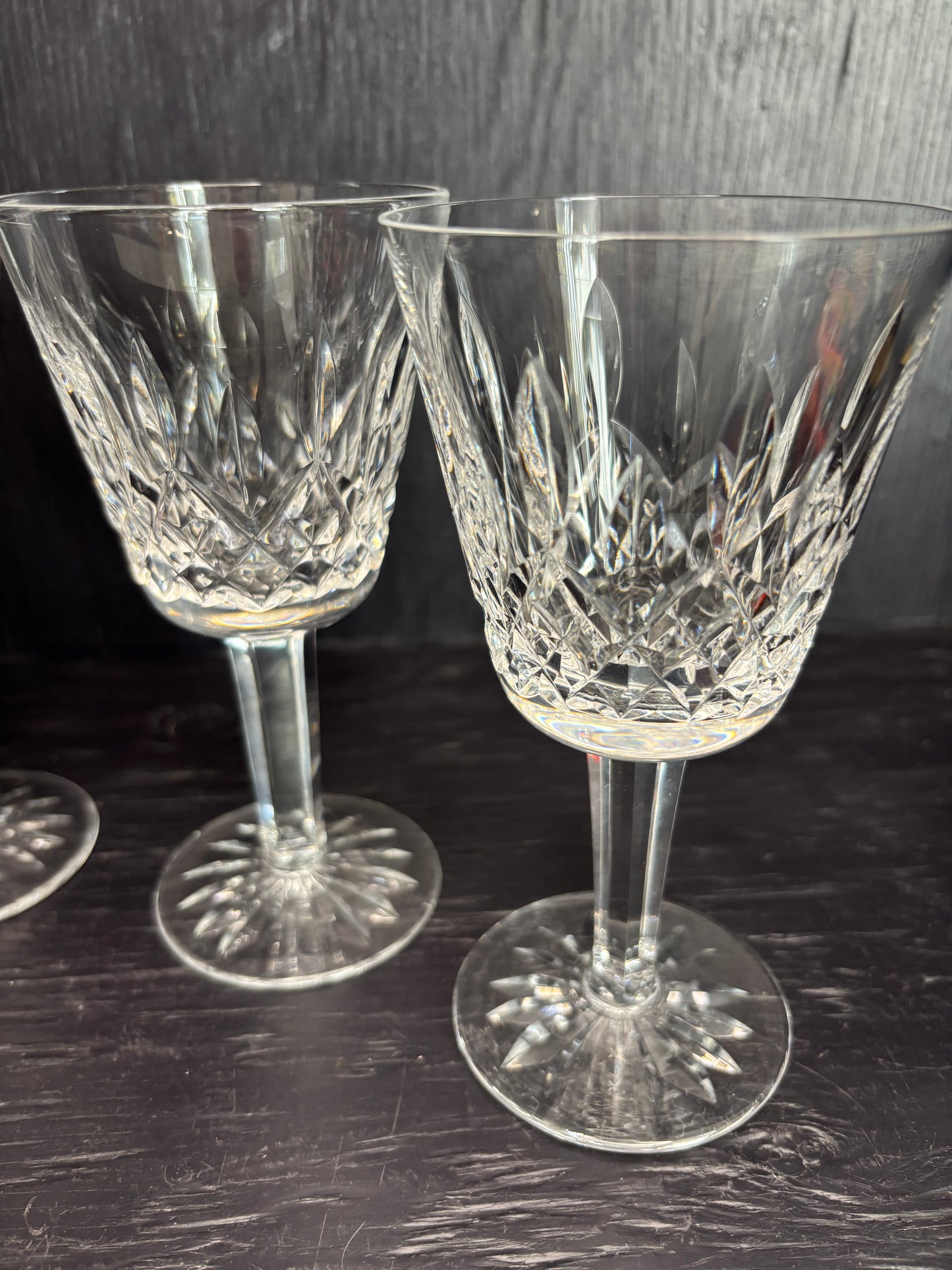 Two crystal wine glasses on a dark surface