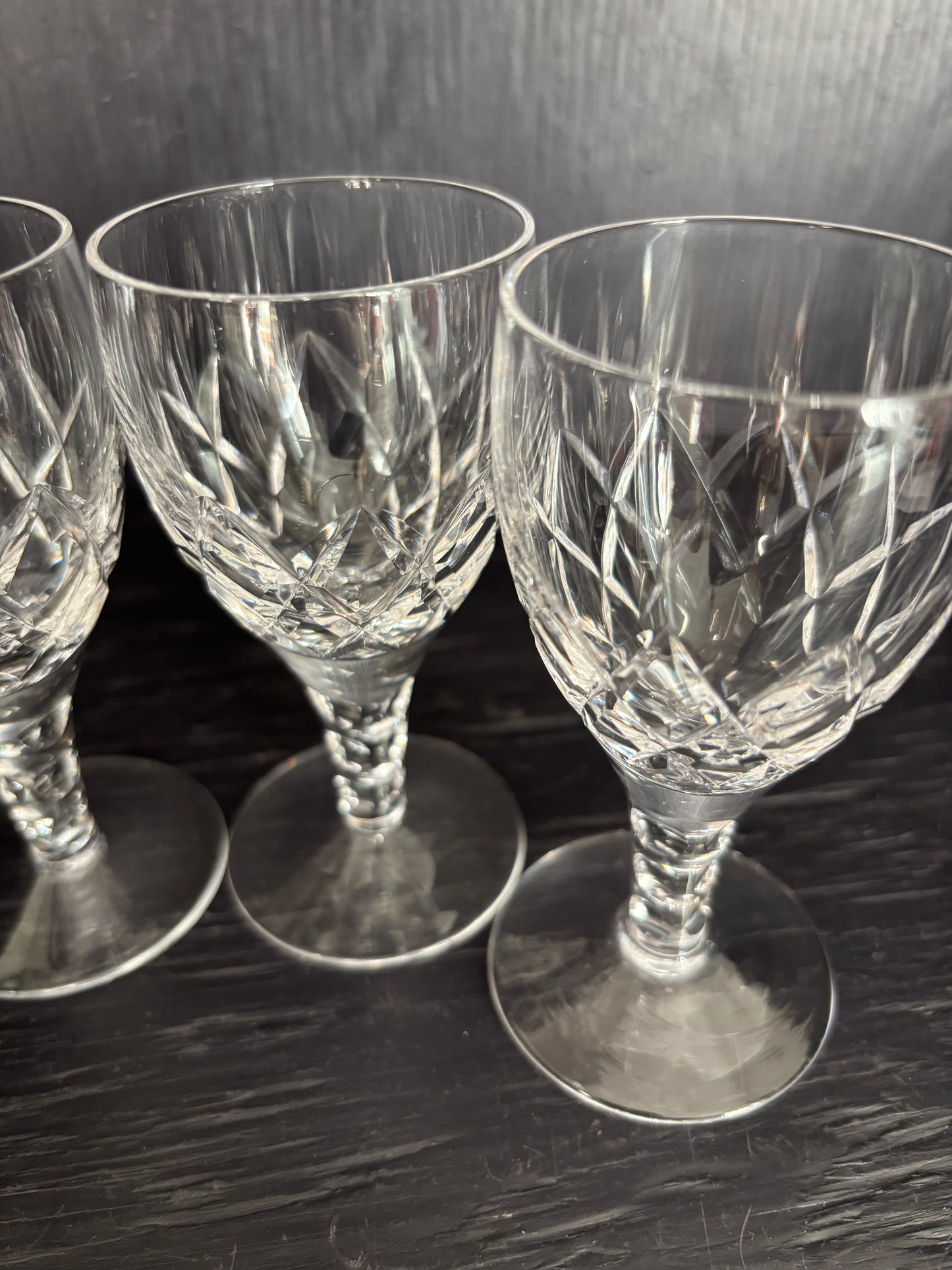 Three crystal glasses on a reflective surface