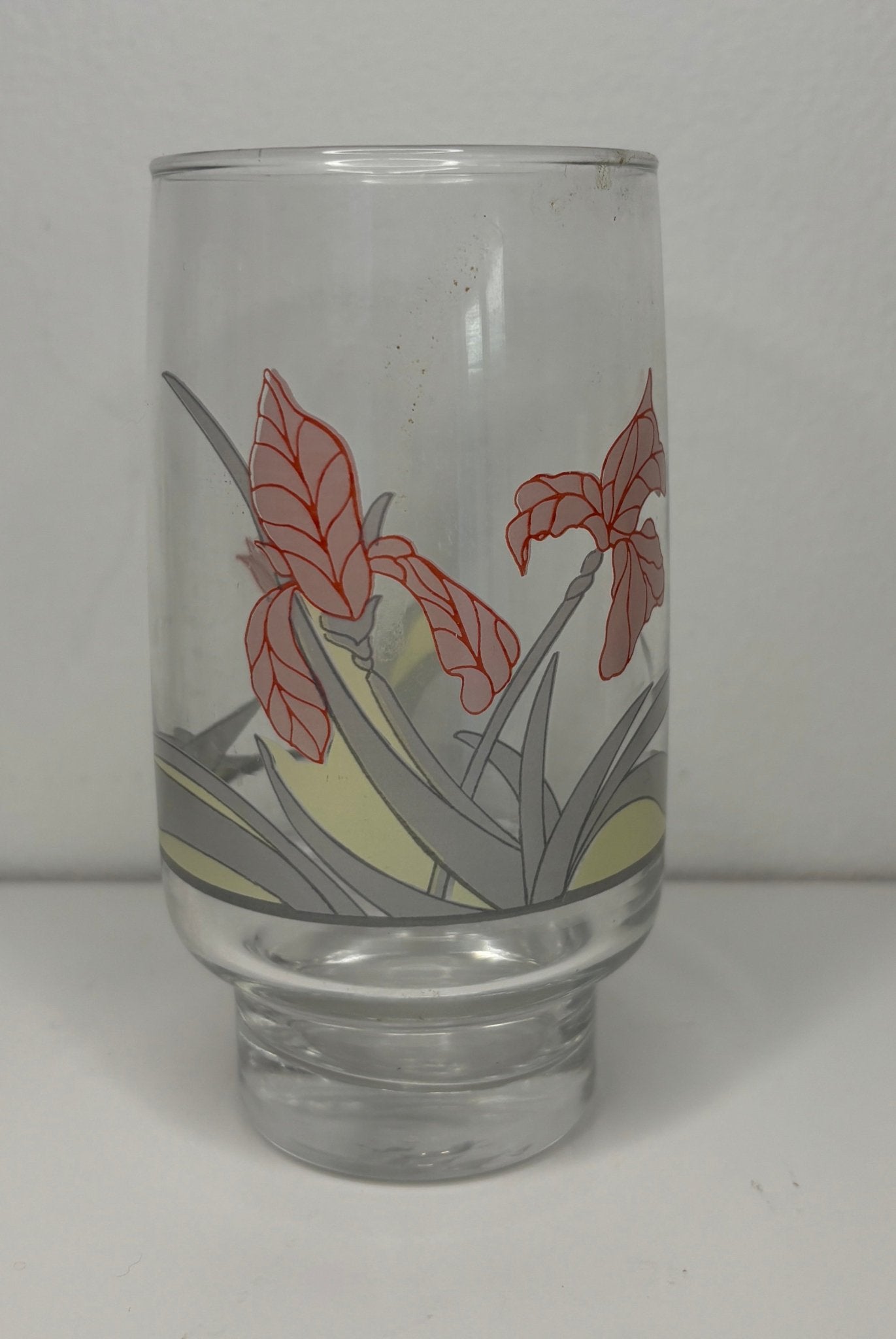 Clear glass tumbler with floral design on a white background