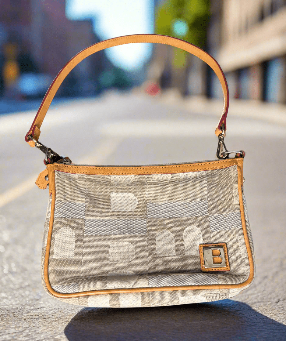 Handbag with geometric pattern and brown handle on a dark surface