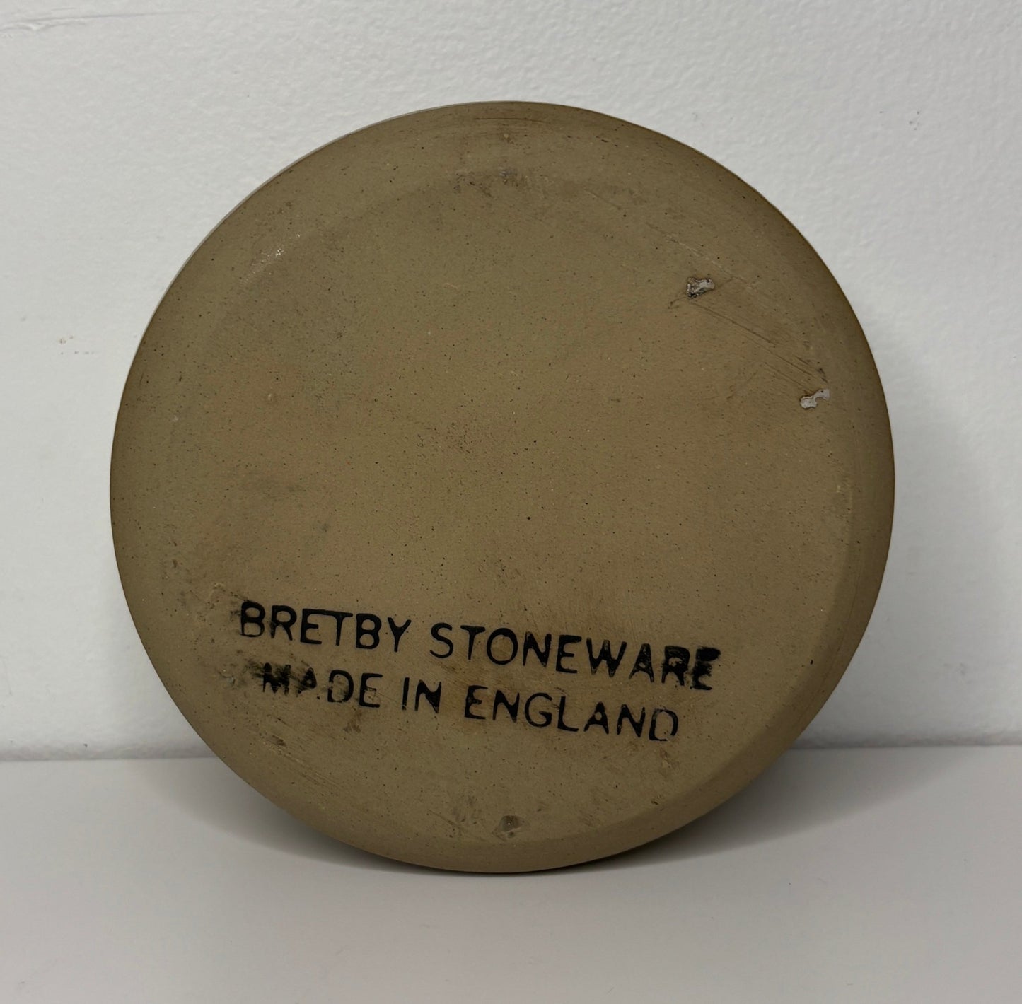 Round Bretby Stoneware plate with 'Made in England' text on a white background