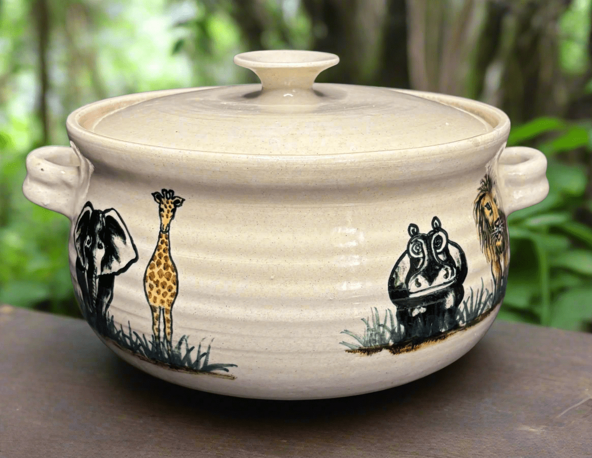 Ceramic pot with animal designs on a wooden surface with a natural background