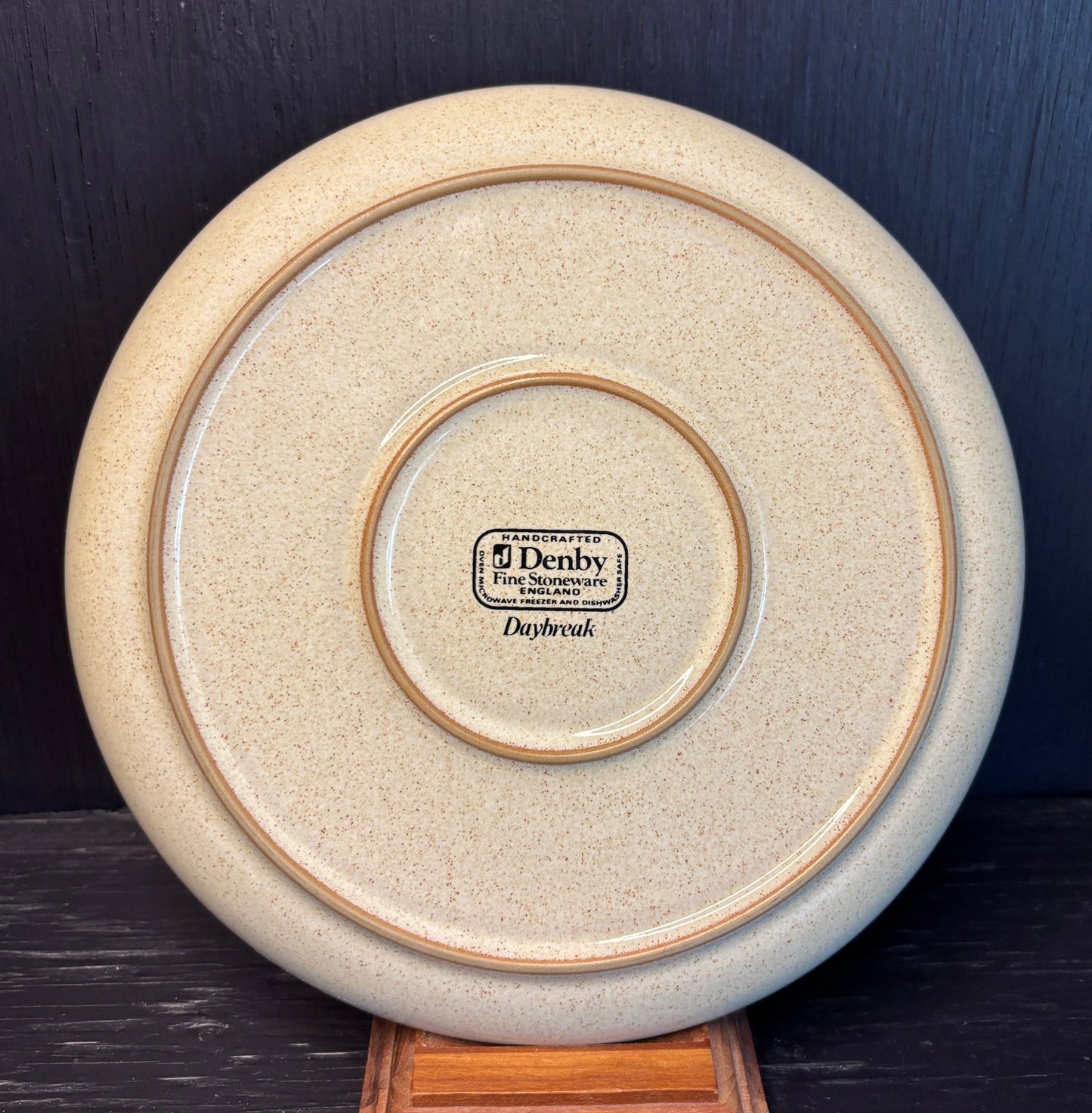 Denby Daybreak Salad Plate with white flower design on a beige background